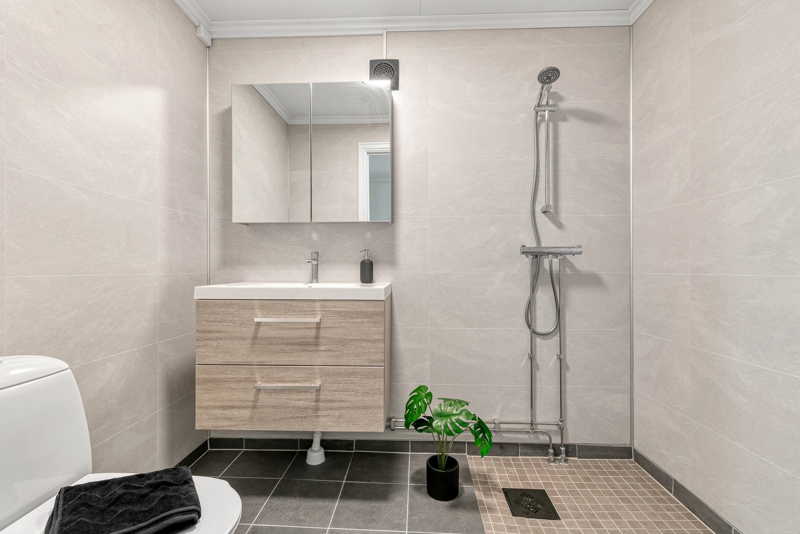 Baderommet er fra megaflis og ble pusset opp i 2024 med gulvvarme og baderomsplater på vegger, men har sluk fra byggeår. Galleribilde