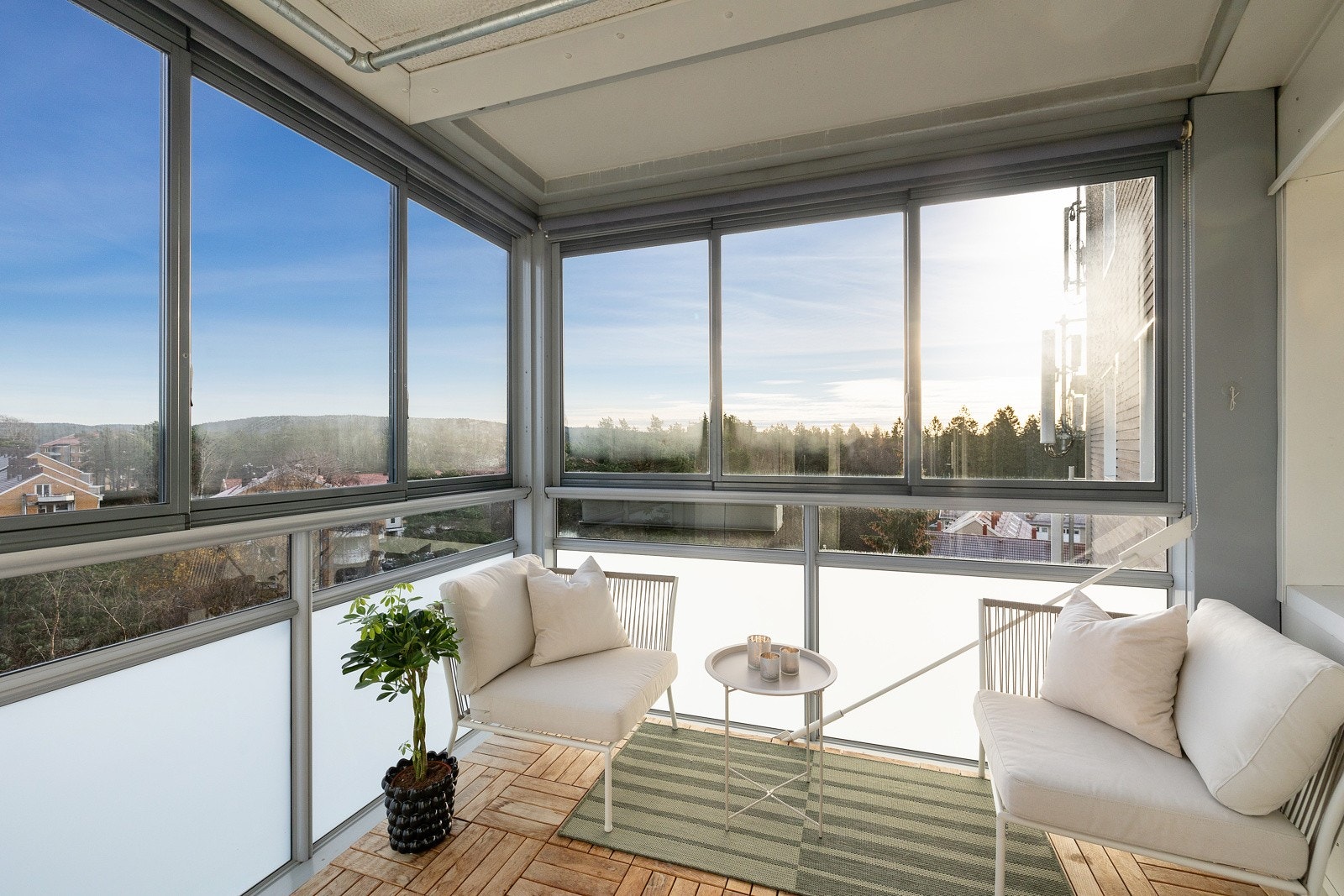 Balkongen er innglasset og glassene kan enkelt åpnes og skyves til side. Det er montert solskjerming på innsiden av glassene. Galleribilde