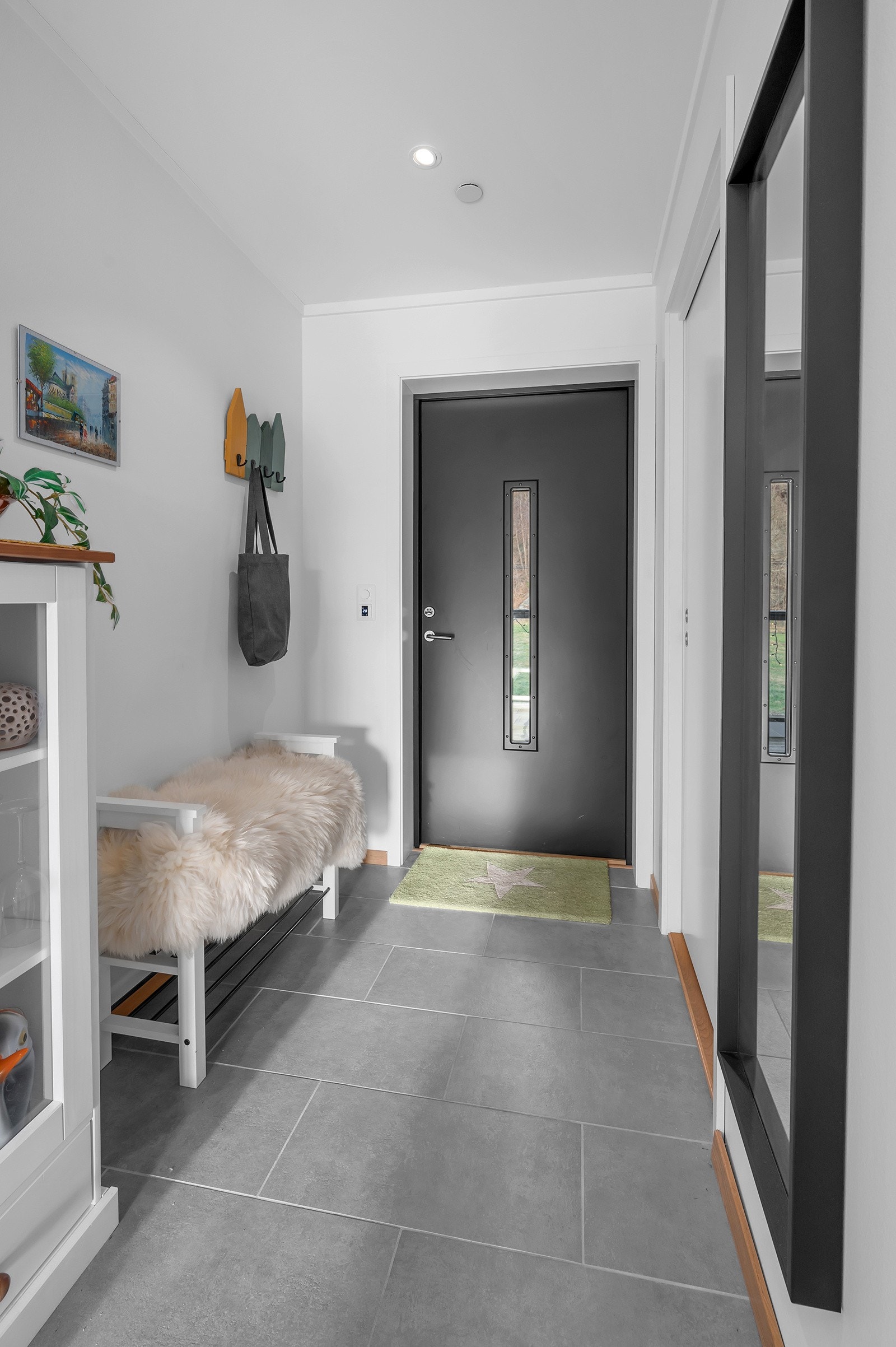 Lys og trivelig flislagt gang med spotdownlights i tak. Galleribilde