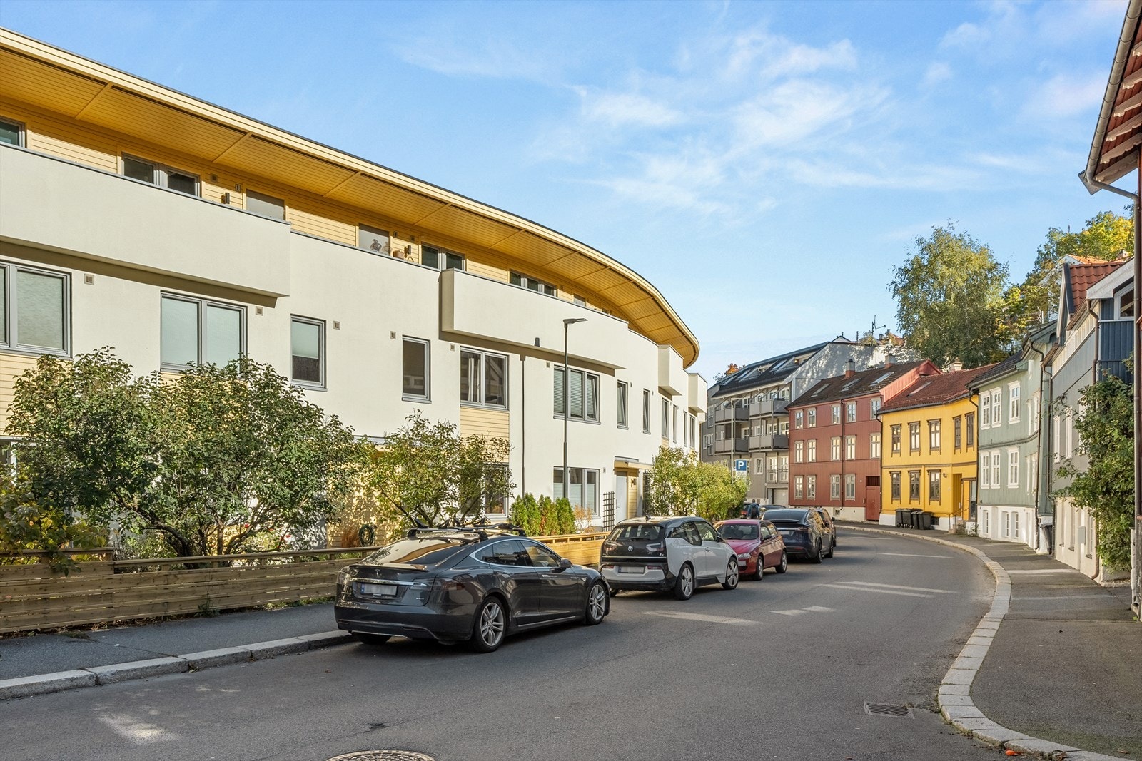 Gaten utenfor har en nydelig atmosfære med syrintrær som blomstrer om våren, fargerike trehus og brede fortau. Galleribilde