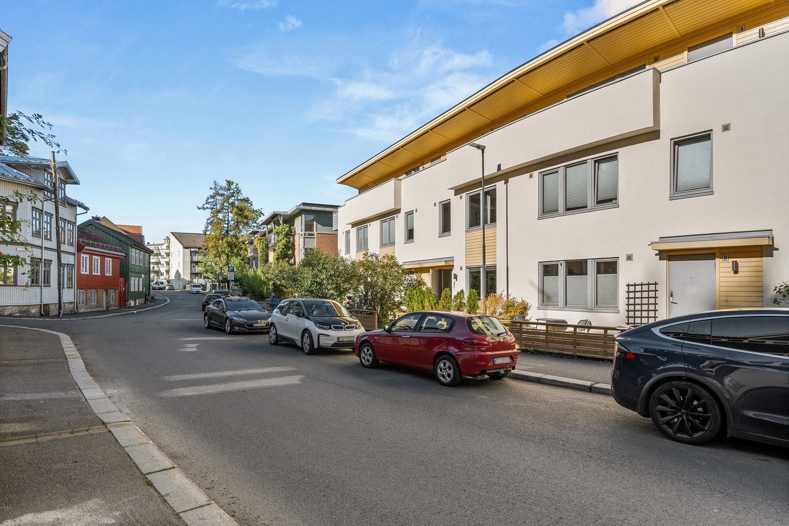 Den moderne fasaden inspirert av funksjonalismen er en fin kontrast til de fargerike trehusene i gaten. Galleribilde