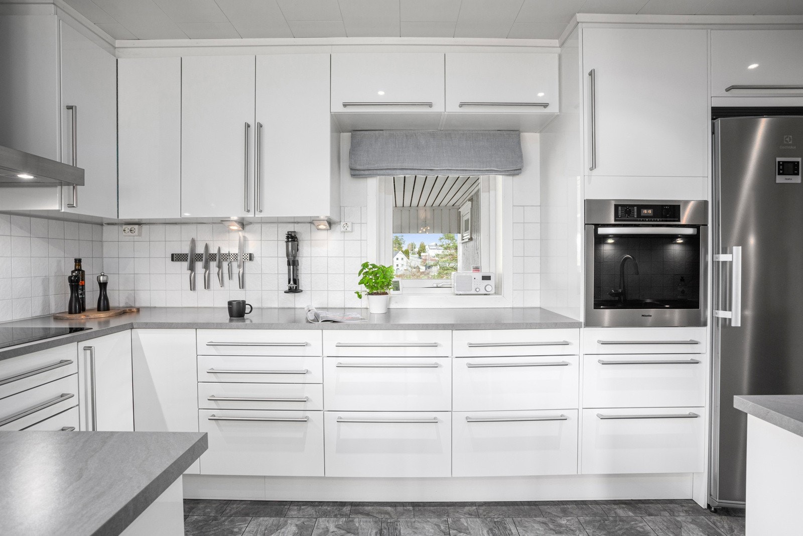 Integrerte hvitevarer som komfyr, oppvaskmaskin, mikrobølgeovn og platetopp bidrar til både funksjonalitet og estetikk. Et frittstående kjøleskap fullfører ensemblet. Alle integrerte hvitevarer følger med. Galleribilde