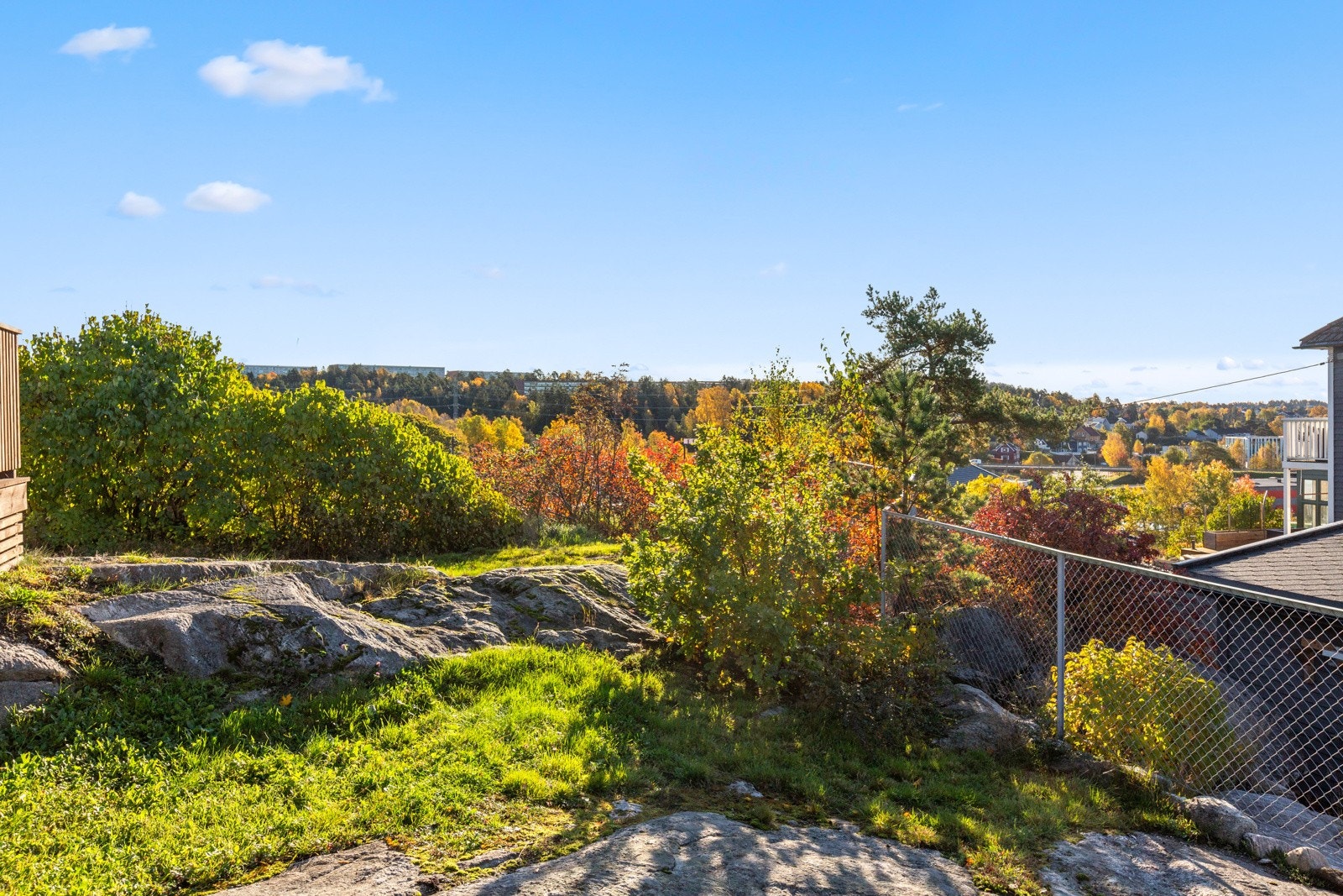 Tomt med partier av fjell og vegetasjon som gir et naturlig og frodig preg. Galleribilde