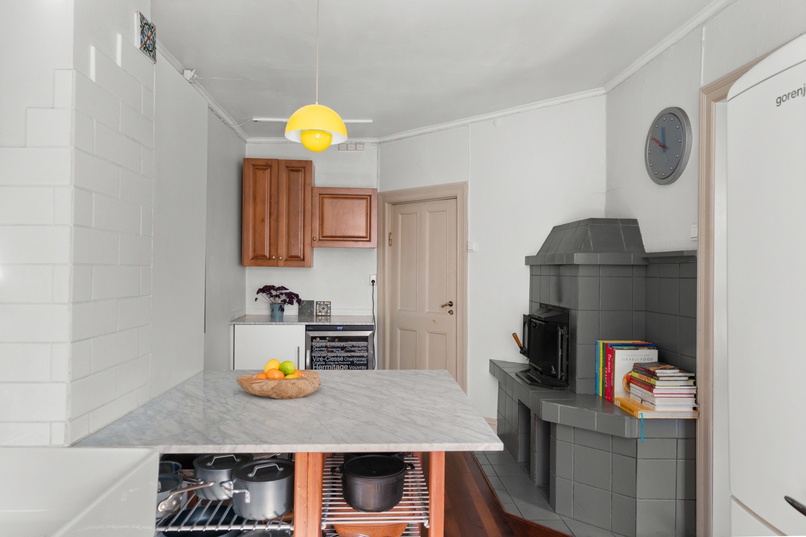 Kjøkkeninnredningen har gylne, profilerte fronter, benkeplate i lys marmor og en stor kum i hvitt porselen. Galleribilde