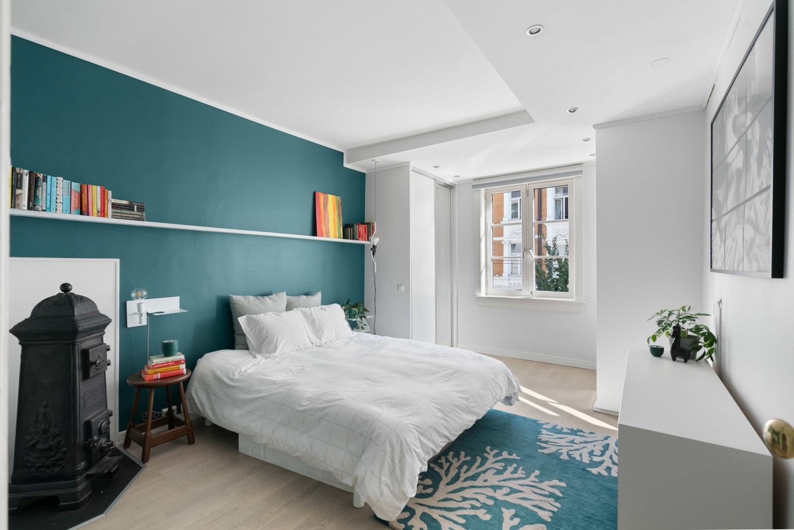 Begge soverommene er pent pusset opp i tidsmessige fargetoner som står godt til parkettgulvene, og det ene soverommet har en klassisk vedovn i støpejern. Galleribilde