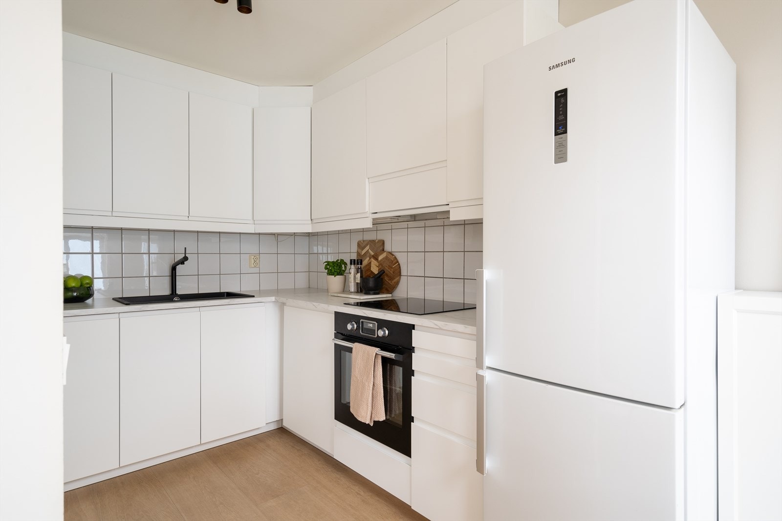 Tidløst kjøkken fra 2021, med innredning fra IKEA. Profilerte fronter, laminat benkeplate med oppvaskkum og ett-greps svingbart blandebatteri. Galleribilde