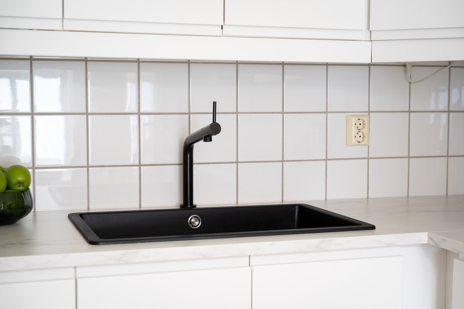 Mellom overskap og benkeplate er det montert fliser på vegg. Galleribilde