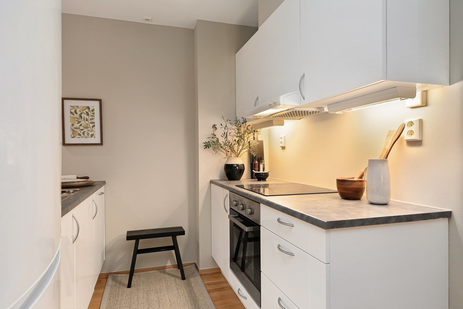 Innredningen har folierte fronter og grå laminat benkeplate med nedfelt stålkum. Galleribilde