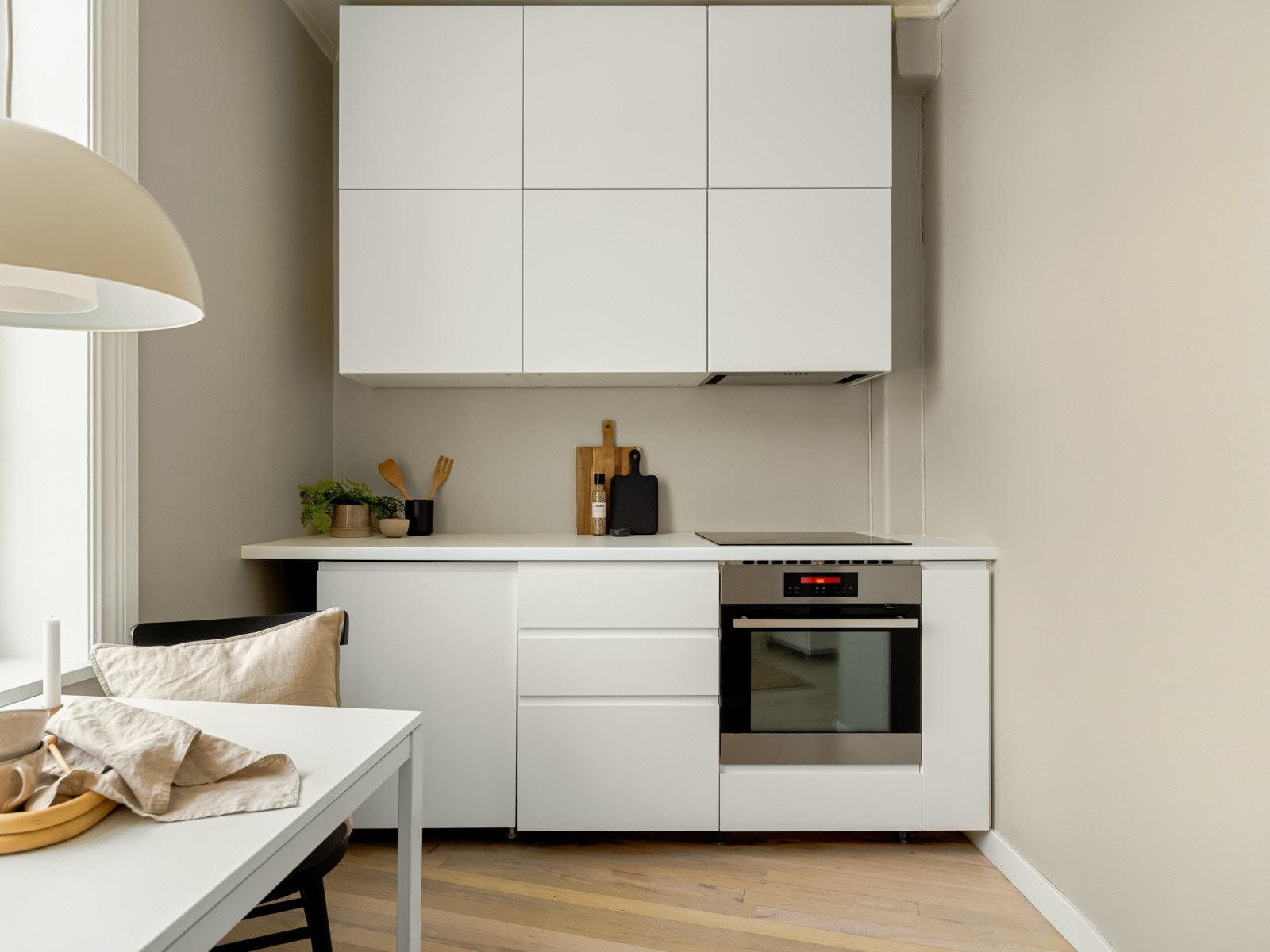 Nyere takhøy kjøkkeninnredning fra Ikea på ene siden med integrert induksjonsplatetopp og stekeovn samt ventilator. Hybeloppvaskmaskin. Galleribilde