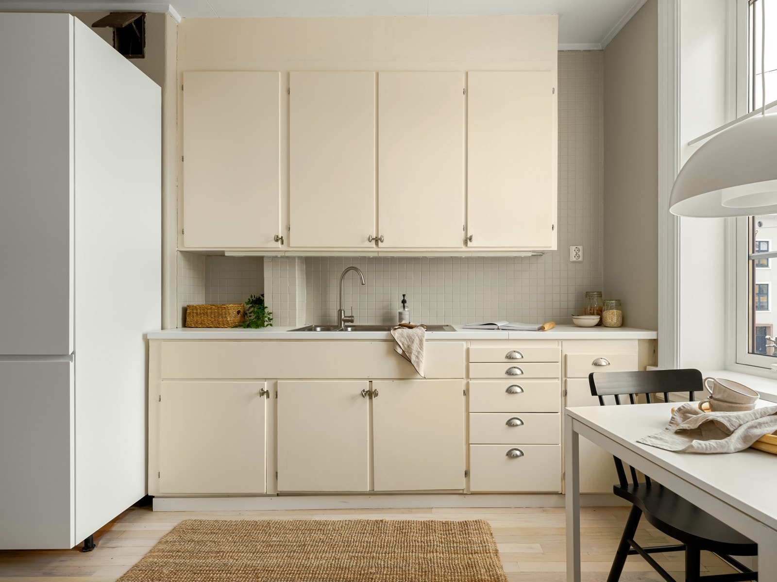 Eldre takhøy kjøkkeninnredning med laminat benkeplate og nedfelt stålkum. Galleribilde