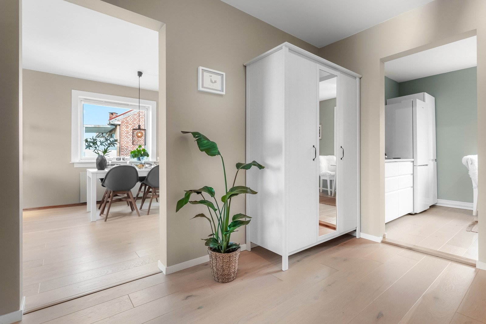 Yttertøyet ryddes enkelt bort i et hvitt garderobeskap med dels speilfronter. Galleribilde