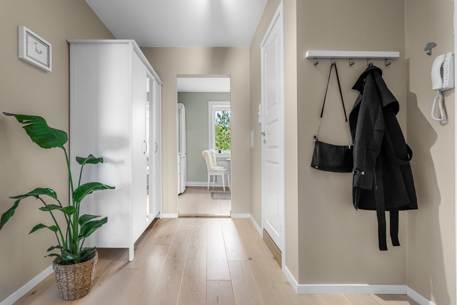 Ytterdøren er fra 2021, og vel inne gir gangen et godt førsteinntrykk av leiligheten. Her er det dørtelefon, 1-stavs laminatgulv og veggflater malt i en lys nyanse. Galleribilde