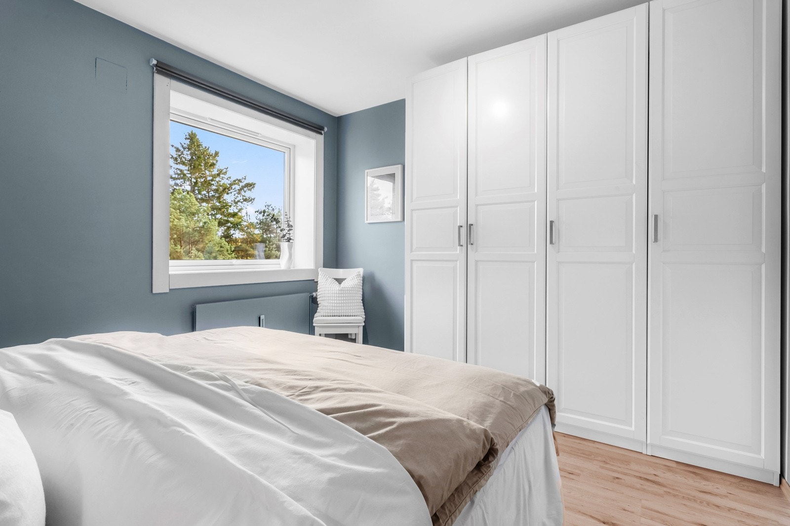 På hovedsoverommet står det et stort og hvitt garderobeskap i profilert utførelse. Galleribilde