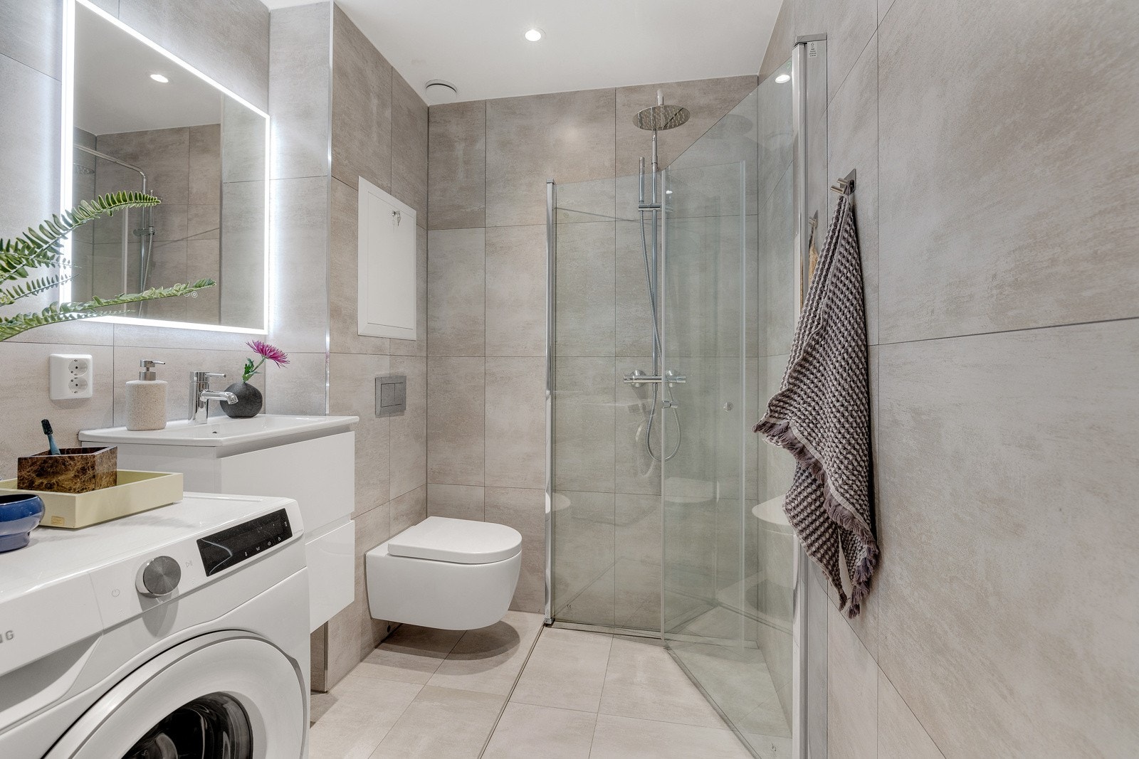 Badet ble ferdig totalrenovert i januar 2024. Som du ser er det plass og opplegg til vaskemaskin. Innfellbare dusjdører bidrar til å spare gulvplass. Galleribilde