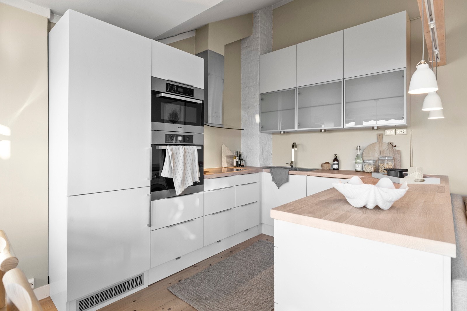 Kjøkkenet har en heltre benkeplate med planlimt kum i kompositt/plast. Det er godt belyst med downlights under overskapene og tre pendellamper. Galleribilde