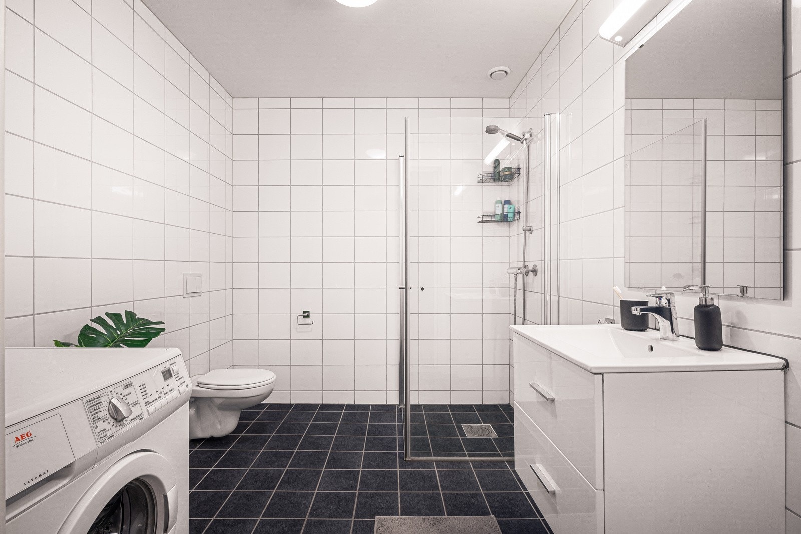 Helfliset bad med varmekabler i gulv, dusjhjørne, vask med underskap, balansert ventilasjon og vegghengt toalett. Galleribilde