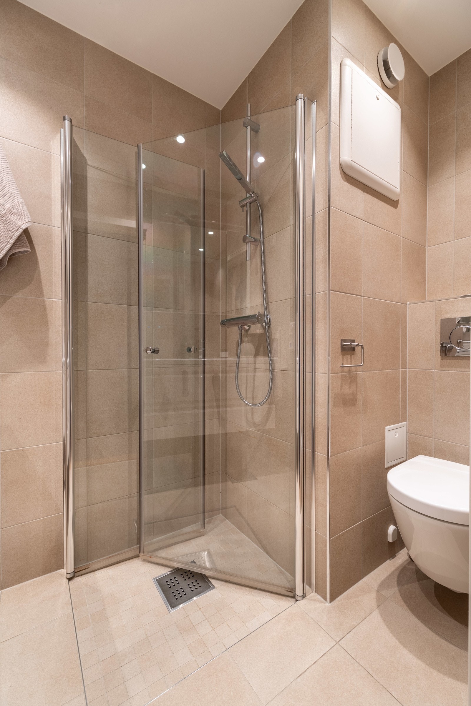 Badet er innredet med vegghengt servantskap med høyglans fronter, heldekkende servant med ett-greps armatur, vegghengt speilskap med overbelysning. dusjhjørne med innfellbare glassdører, samt vegghengt toalett. Galleribilde