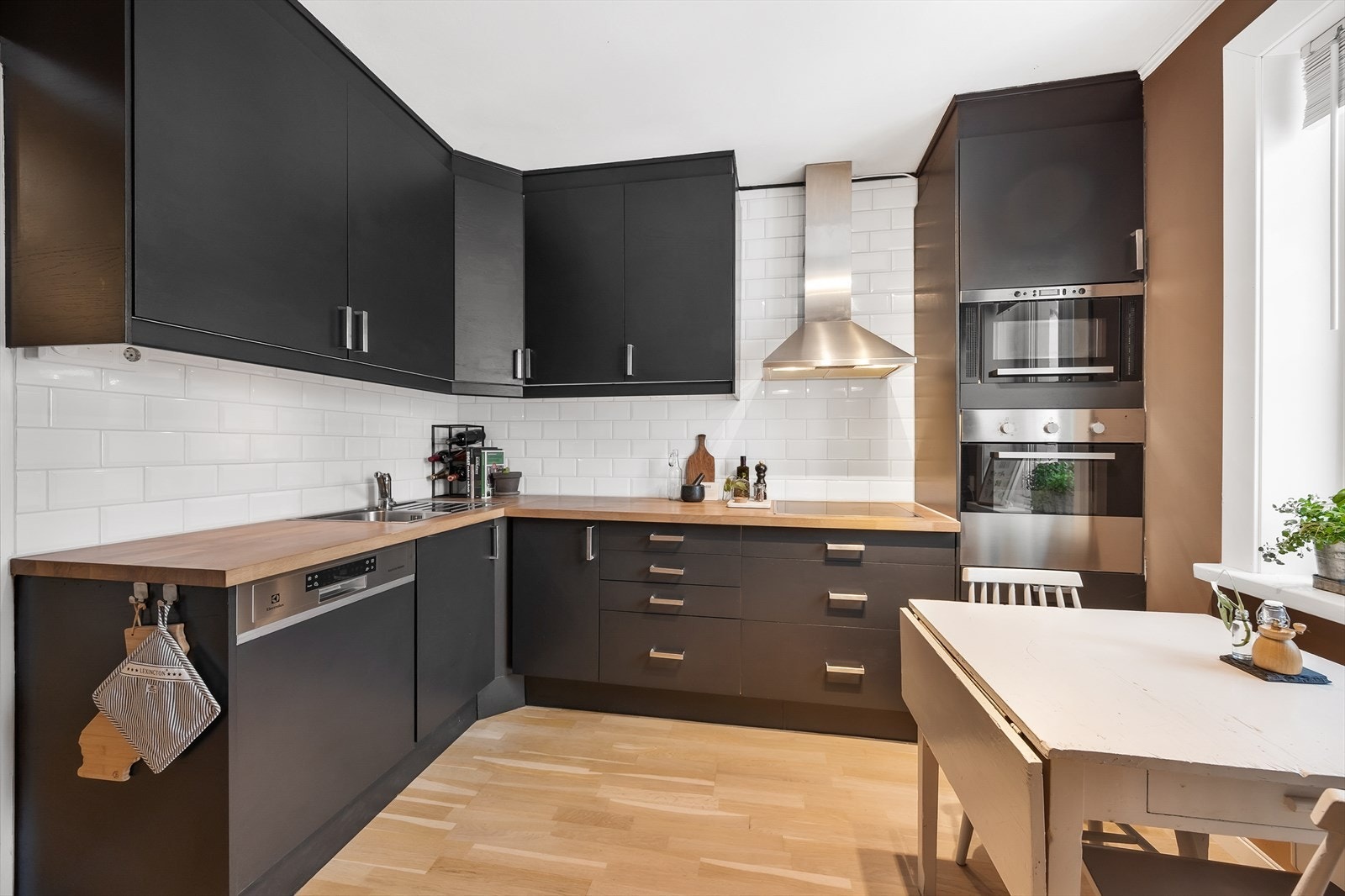 Kjøkken med stilige skap og benkeplater. Galleribilde