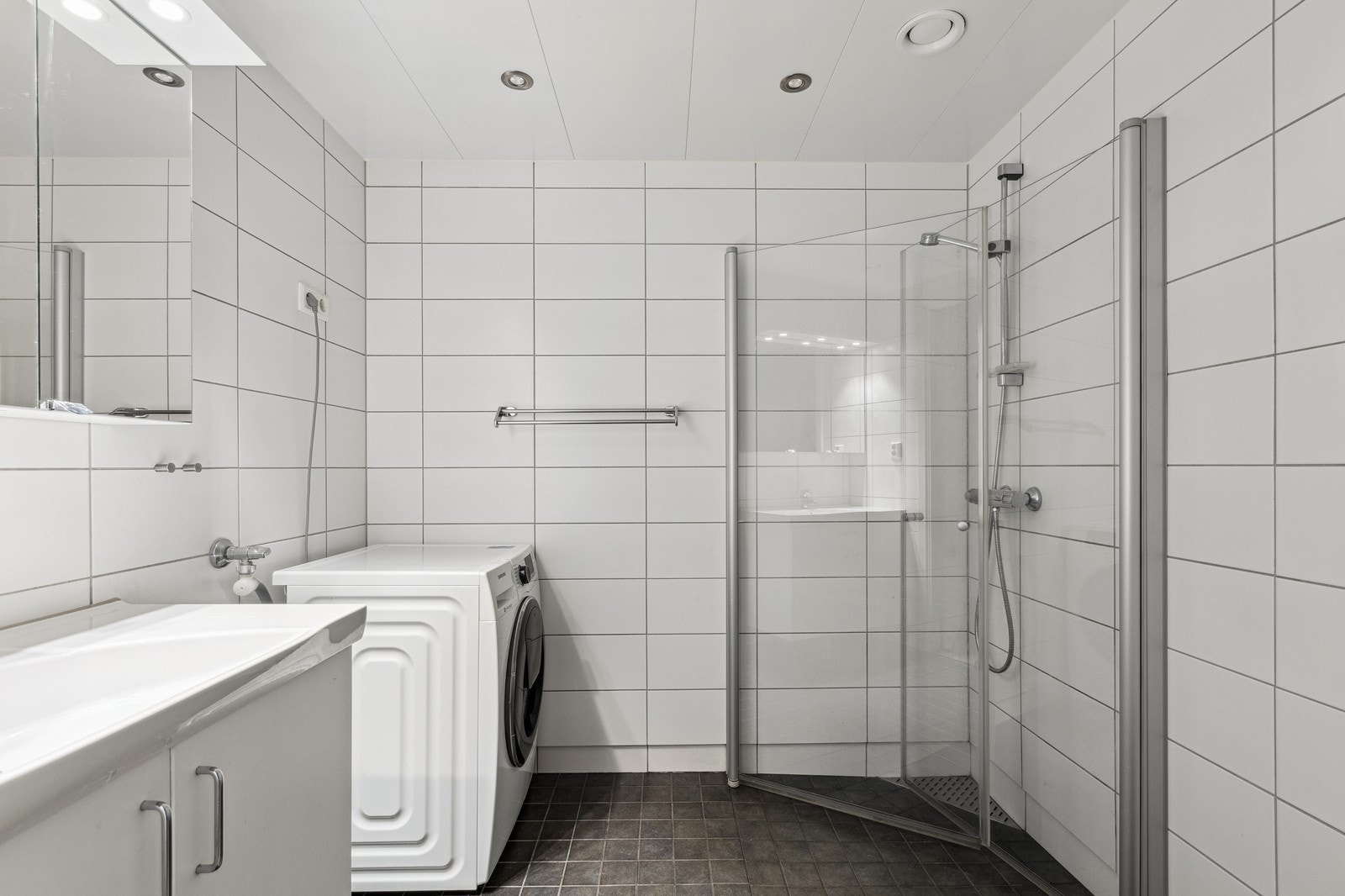 Fint flislagt bad med innfellbare dusjvegger og downlights. Vaskemaskin medfølger Galleribilde