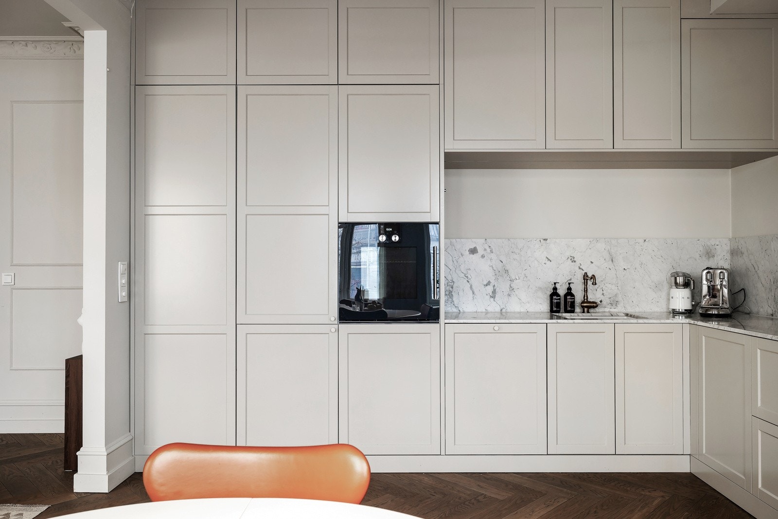 Innredningen har beige, profilerte fronter, samt marmor benkeplate og backsplash Galleribilde