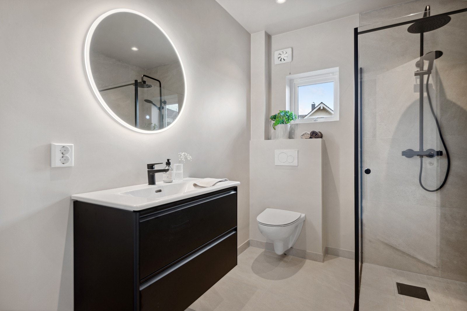 Lekkert bad med fliser på golv og dusjnisje og malte plater på veggane. Det er lekre fargeval og svarte detaljer. Galleribilde