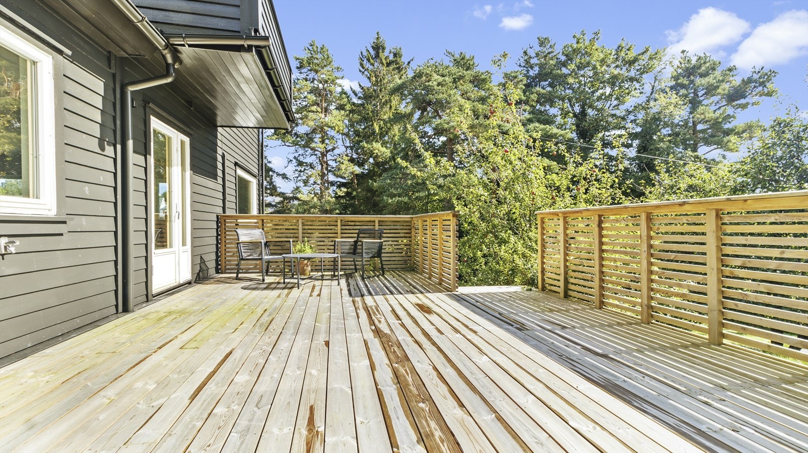 Det er eit moderne spilerekkverk rundt terrassen, med trapp ned til hagen. Galleribilde