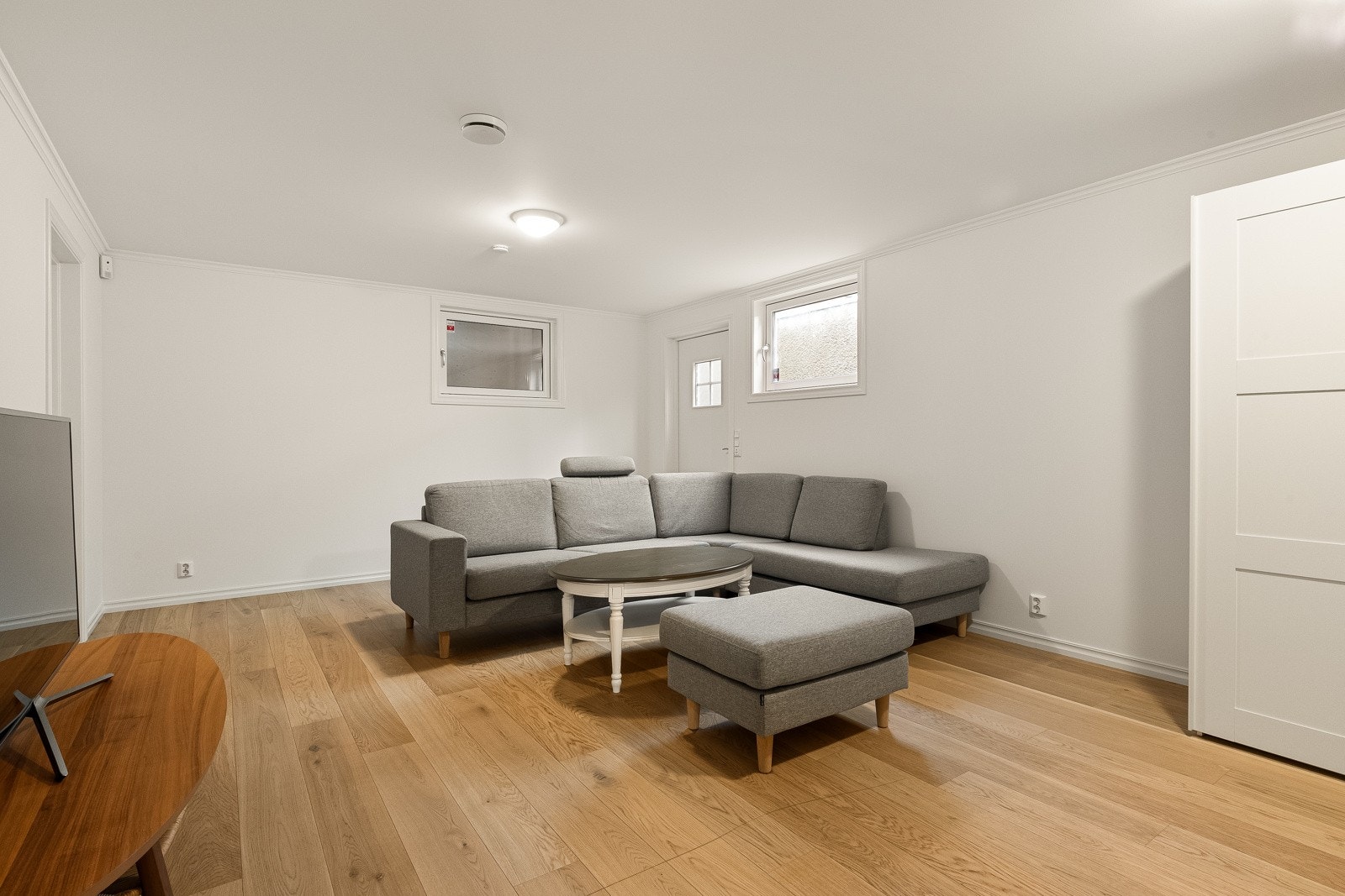 Stuen i underetasjen har rikelig med plass til en stor sofaseksjon og annet ønsket møblement, noe som gjør rommet ideelt for både avslapning og sosiale sammenkomster. Galleribilde