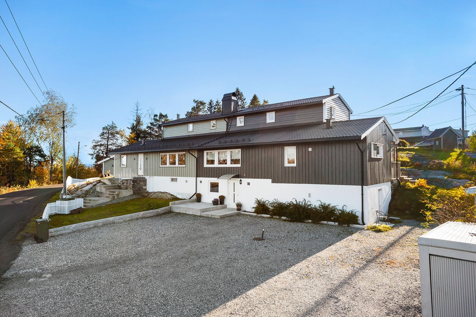 Boligens utvendige fasade med stor og romslig gårdsplass. Her har man god plass for å parkere bilen. Galleribilde