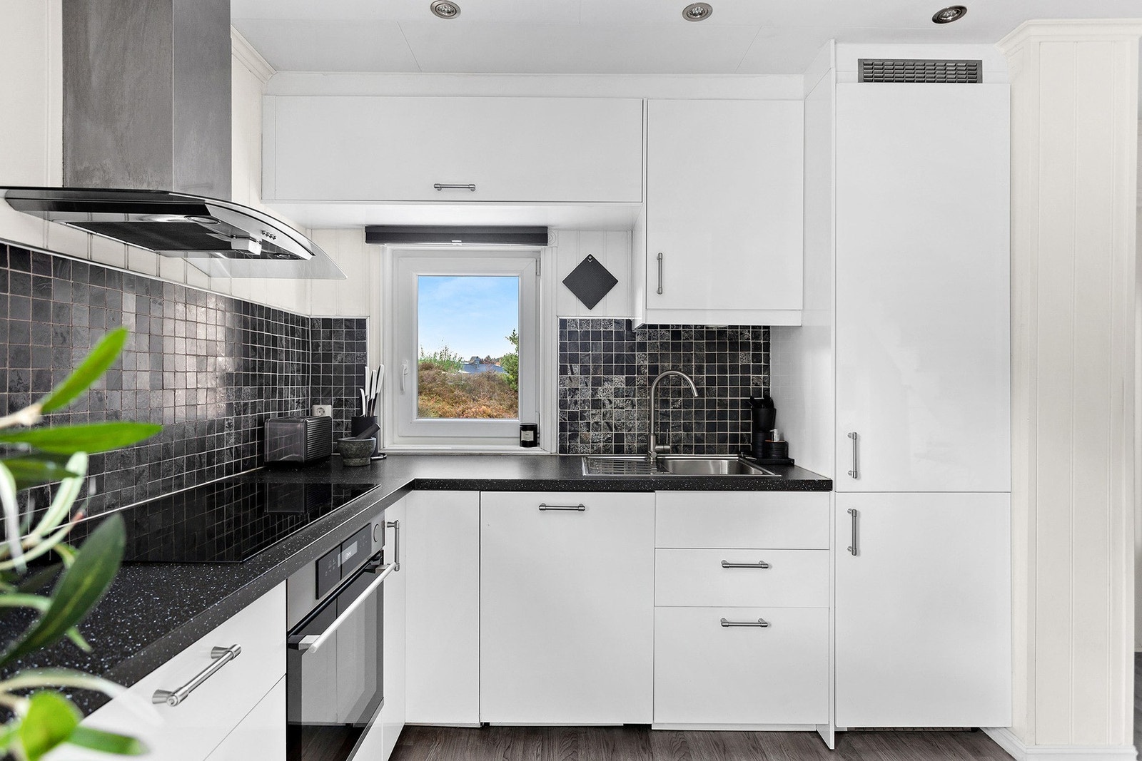 Innredningen består av hvite høyglans fronter, laminert benkeplate og integrerte hvitevarer. Galleribilde