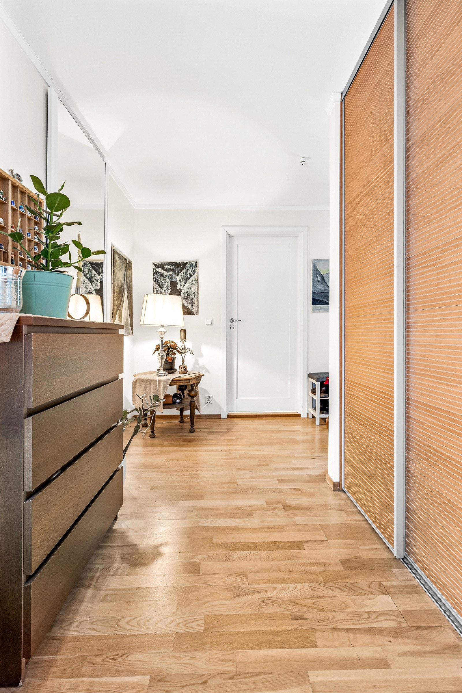 Romslig entré og gang med skyvedørsgarderobe for yttertøyet. Galleribilde