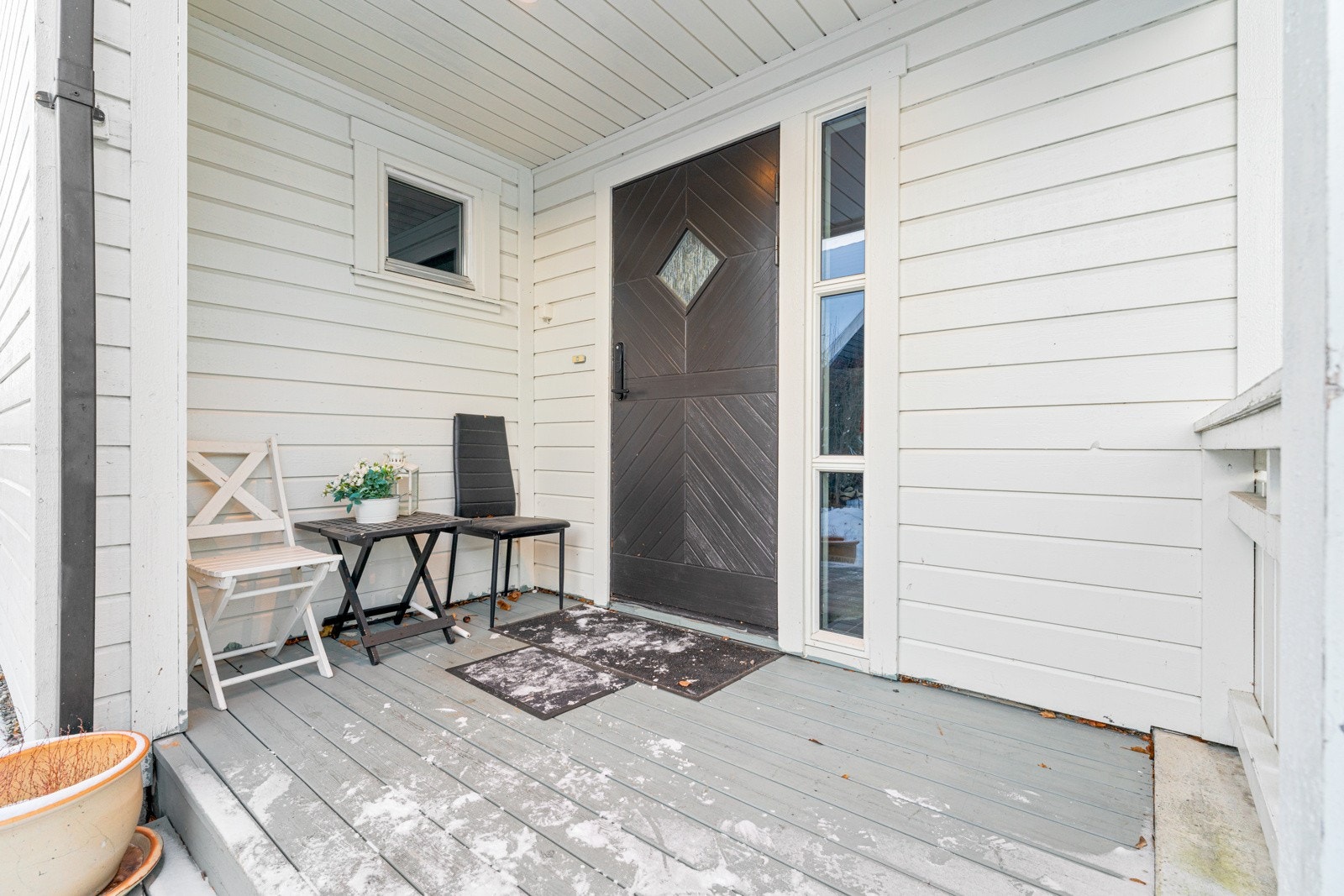 Overbygget inngangsparti med terrasseplatting. Galleribilde