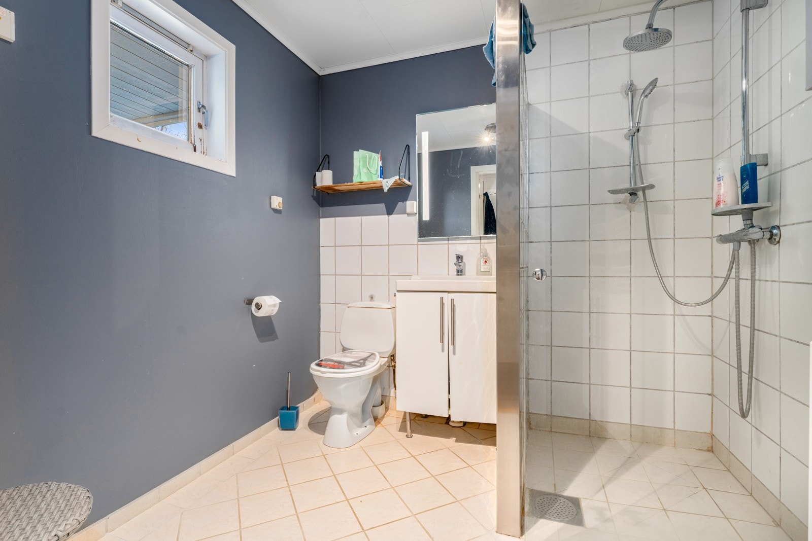 Badet har innredning med speil og belysning, dusjhjørne med glassbyggersteinvegg. Galleribilde