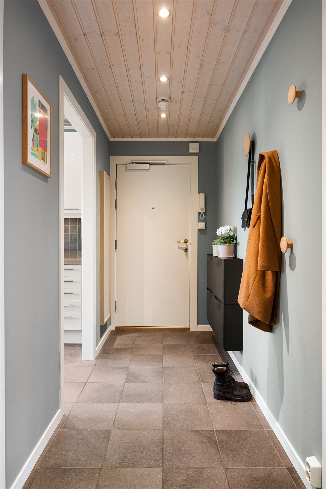 Velkommen inn! Leiligheten har en innbydende entré med flislagt gulv og downlights i himlingen, som gir et moderne og godt førsteinntrykk. Her finner du praktisk plass til å henge fra deg yttertøy og sette fra deg sko. Galleribilde