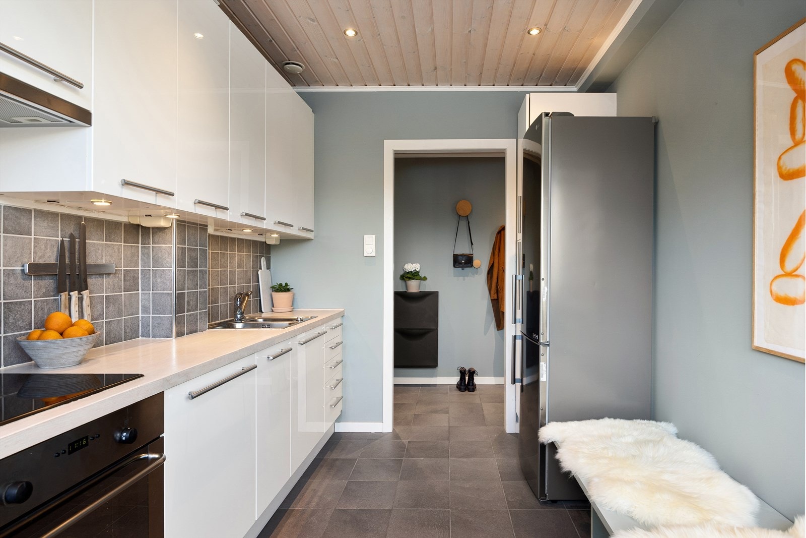 Kjøkkenet har et flislagt gulv og downlights i himlingen, som gir både et stilrent uttrykk og god belysning. Galleribilde