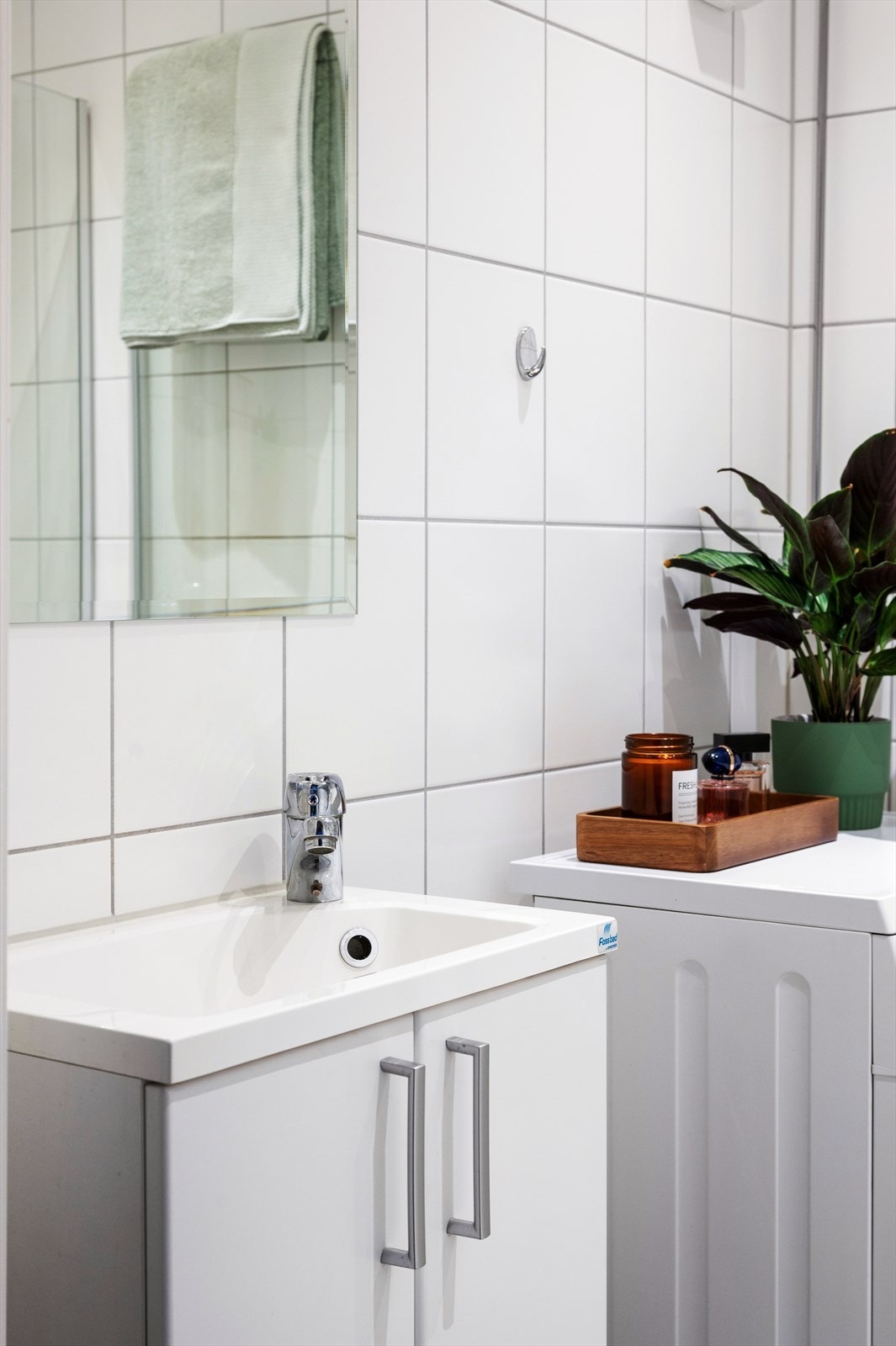 Badet har vannbåren gulvvarme og er innredet med vegghengt klosett, servant på innredning og dusjhjørne med svingbare dører. Galleribilde