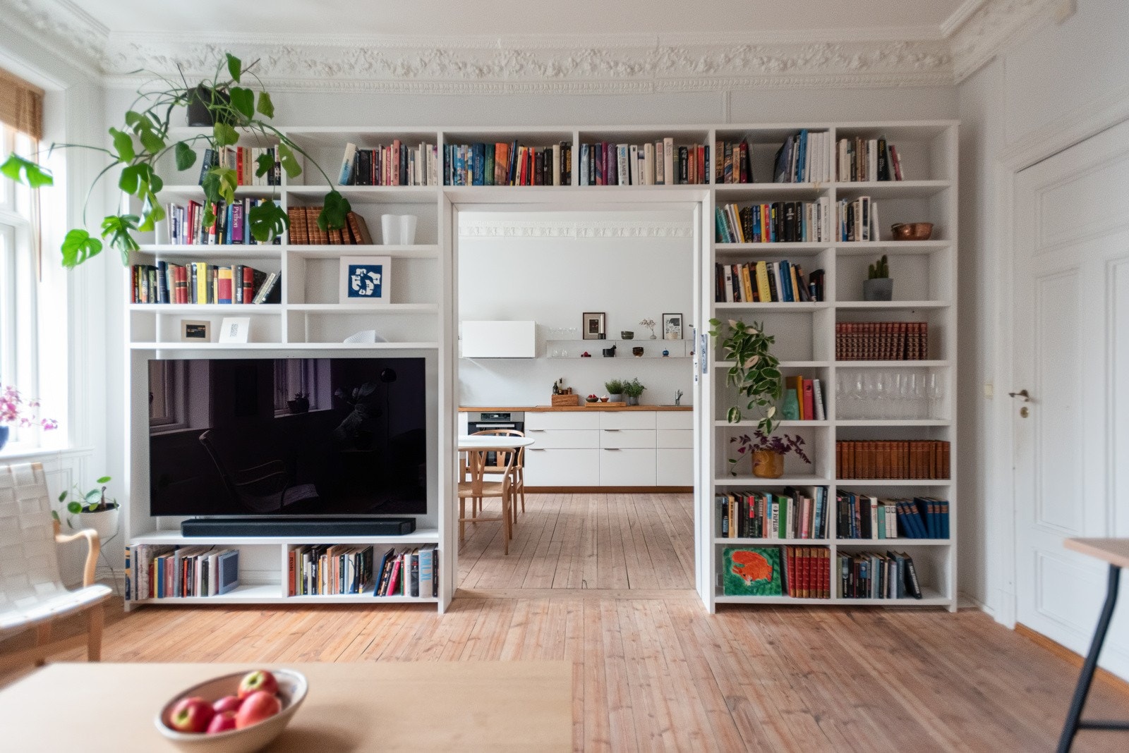 Romslig og innbydende stue innredet med plassbygd bokhylle. Galleribilde