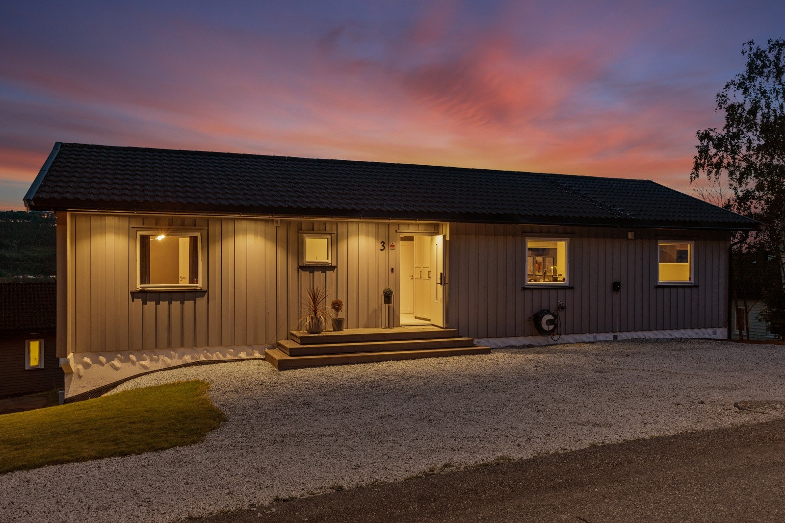 Stor gårdsplass med flere parkeringsplasser og elbillader. Galleribilde