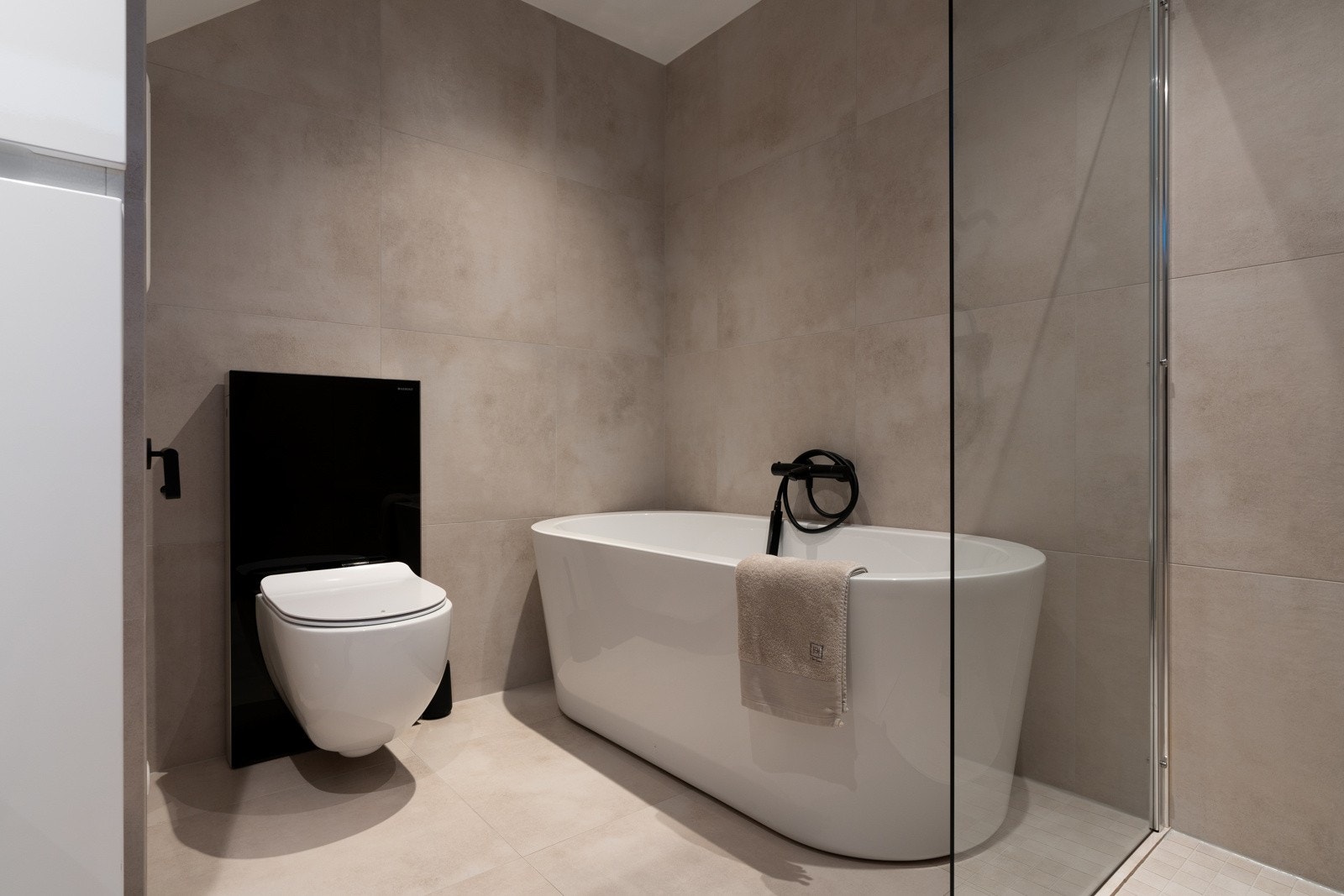 Badet er utstyrt med både dusjhjørne og badekar, samt praktisk vegghengt toalett. Galleribilde