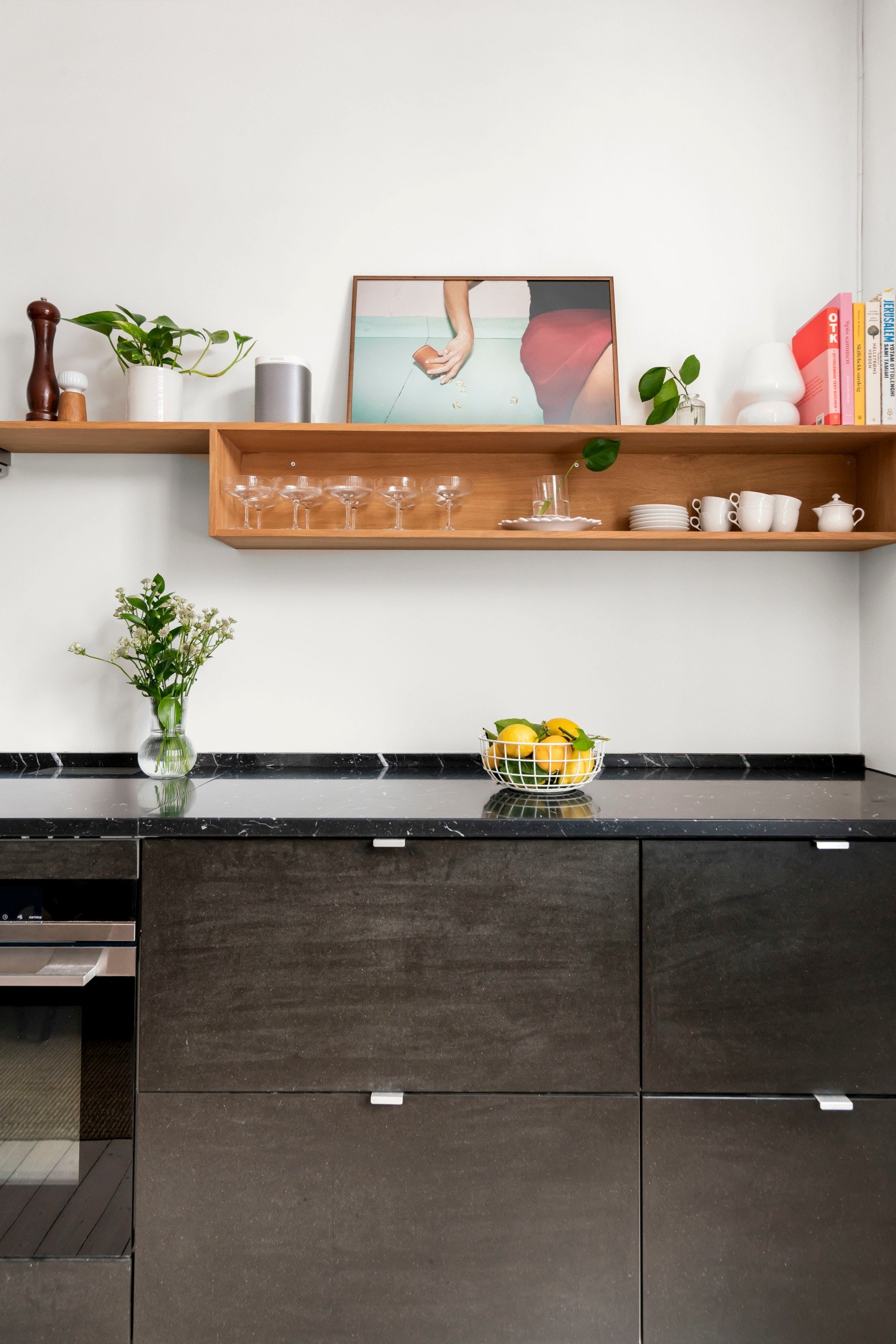 Eksklusiv benkeplate på kjøkken i sort marmor. Lekker hylle bygget av Fjørens Møbelsnekkeri. Galleribilde