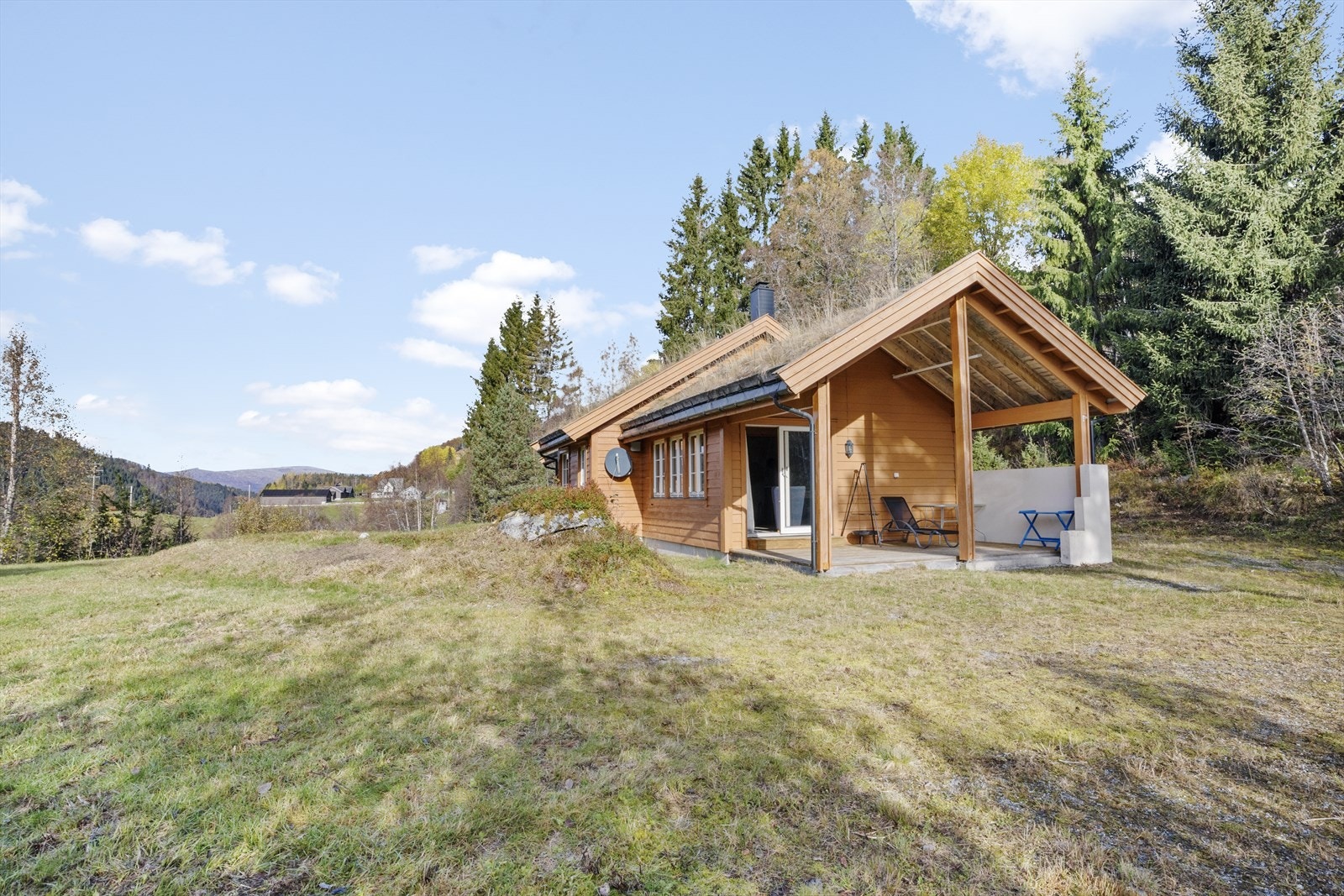 Torvtaket fremhever den harmoniske tilknytningen til omgivelsene, mens uteplassen byr på gode muligheter for avslapning Galleribilde