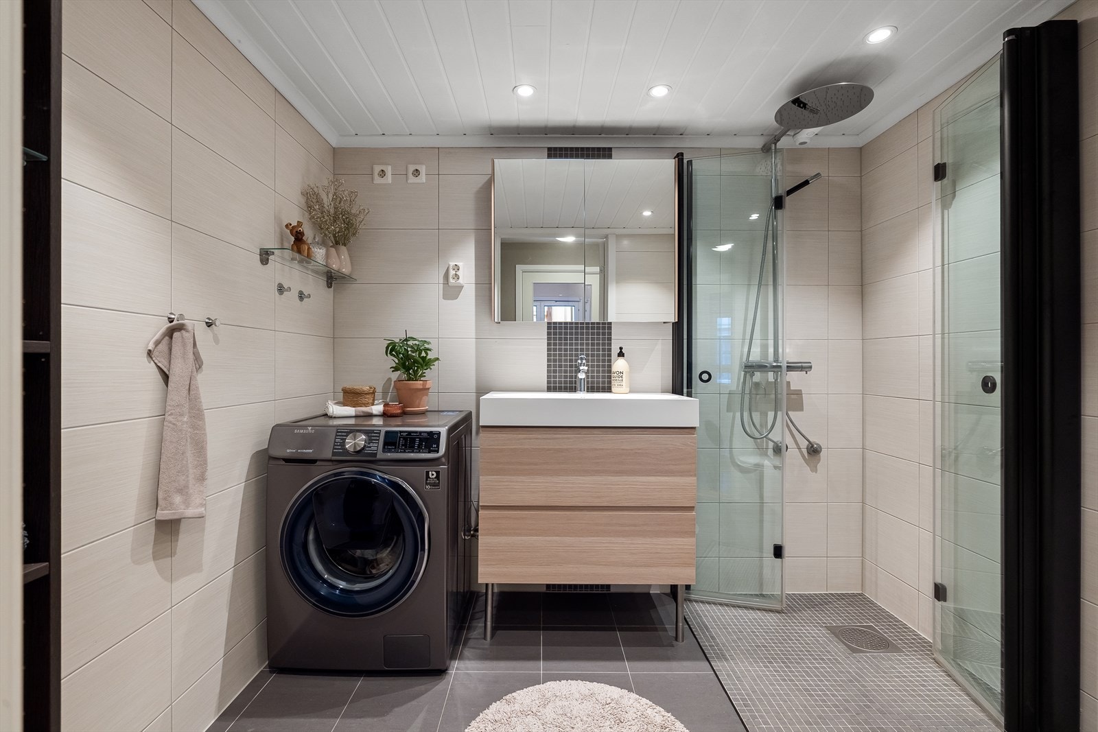 Pent baderom med flislagte overflater, behagelig gulvvarme og downlights i himling. Galleribilde