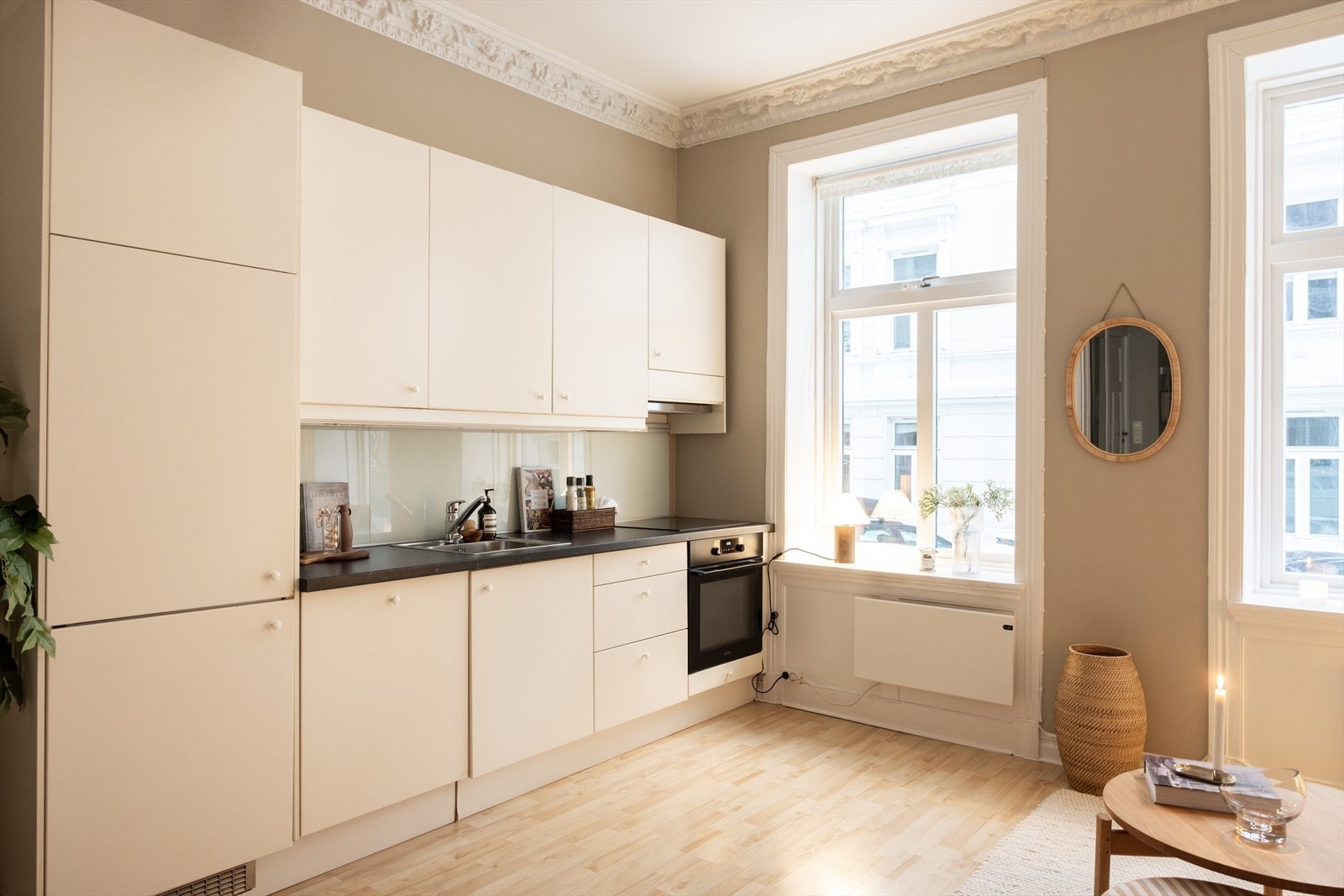 Innbydende og stilrent kjøkken med kjøkkeninnredningen bestående av hvite, glatte fronter og benkeplate av laminat med nedfelt vaskekum. Galleribilde