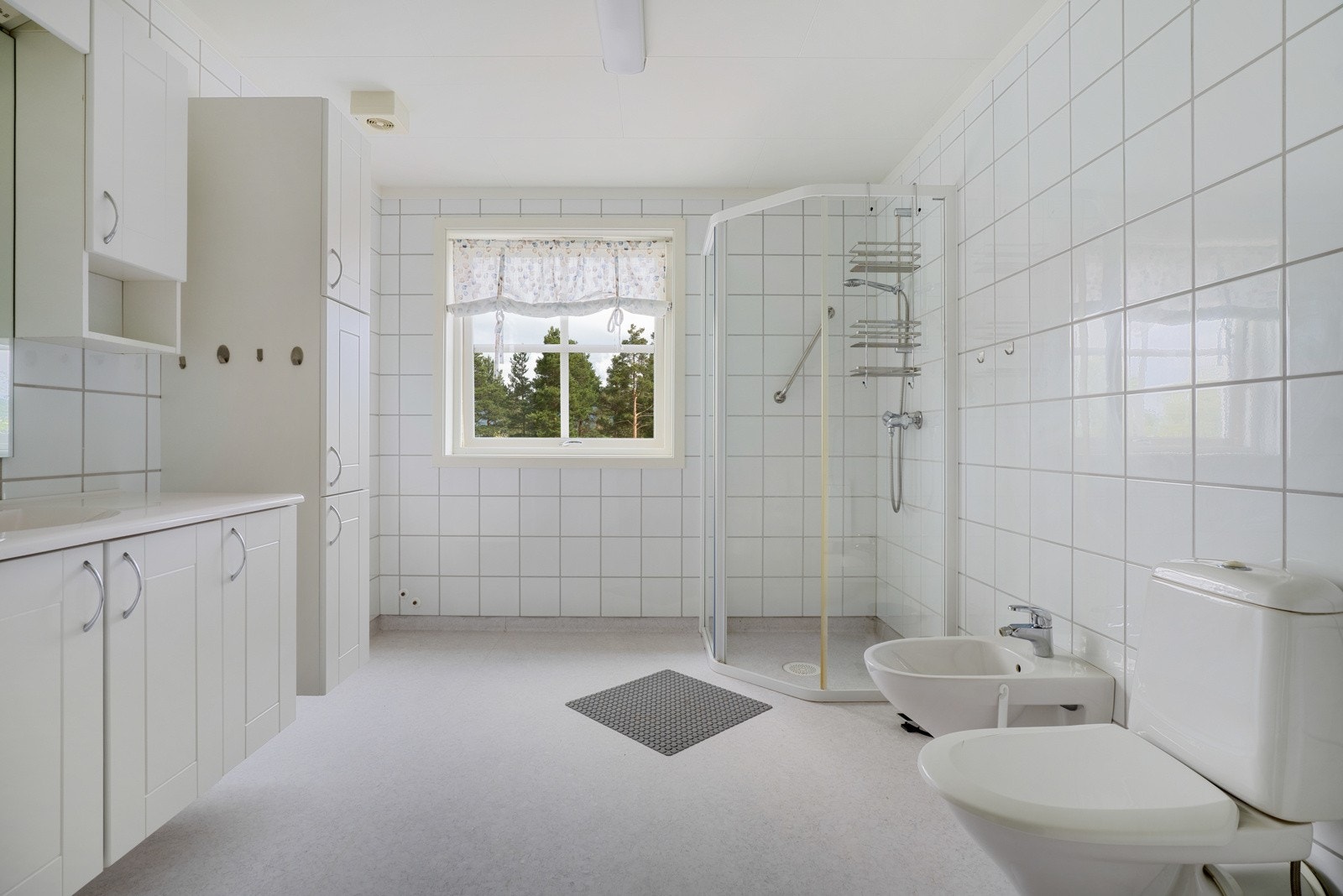 Badet er innredet med servantinnredning, toalett og dusjhjørne. Galleribilde