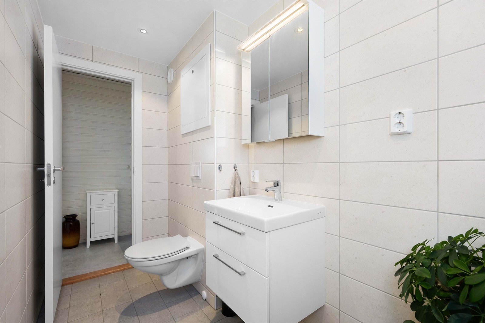 Badet er helfliset i lyse farger og det er opplegg for vaskemaskin. Galleribilde