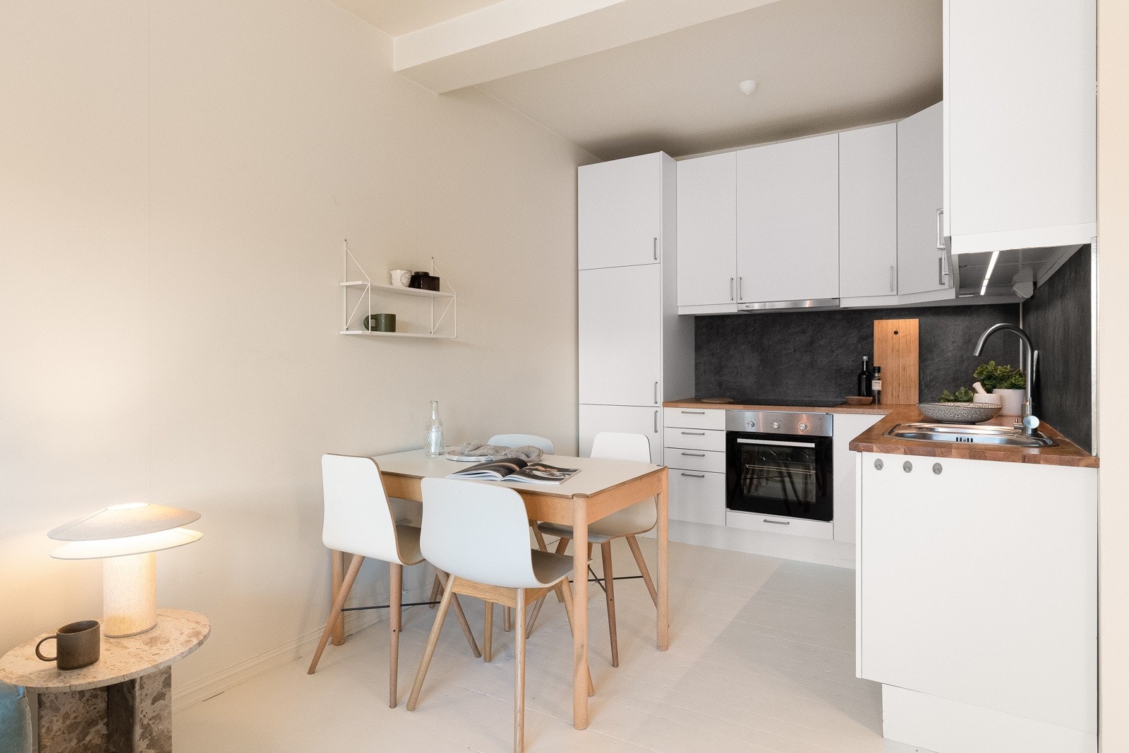 Kjøkkenet har en stilren innredning fra 2017 med hvite, glatte fronter og benkeplate i heltre eik. Galleribilde