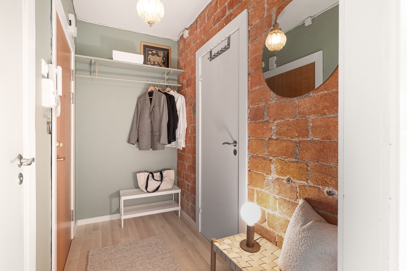Entréen/gangen har en stilig kontrastvegg av blottlagt teglstein. Allerede her får du et godt førsteinntrykk av leiligheten! Galleribilde