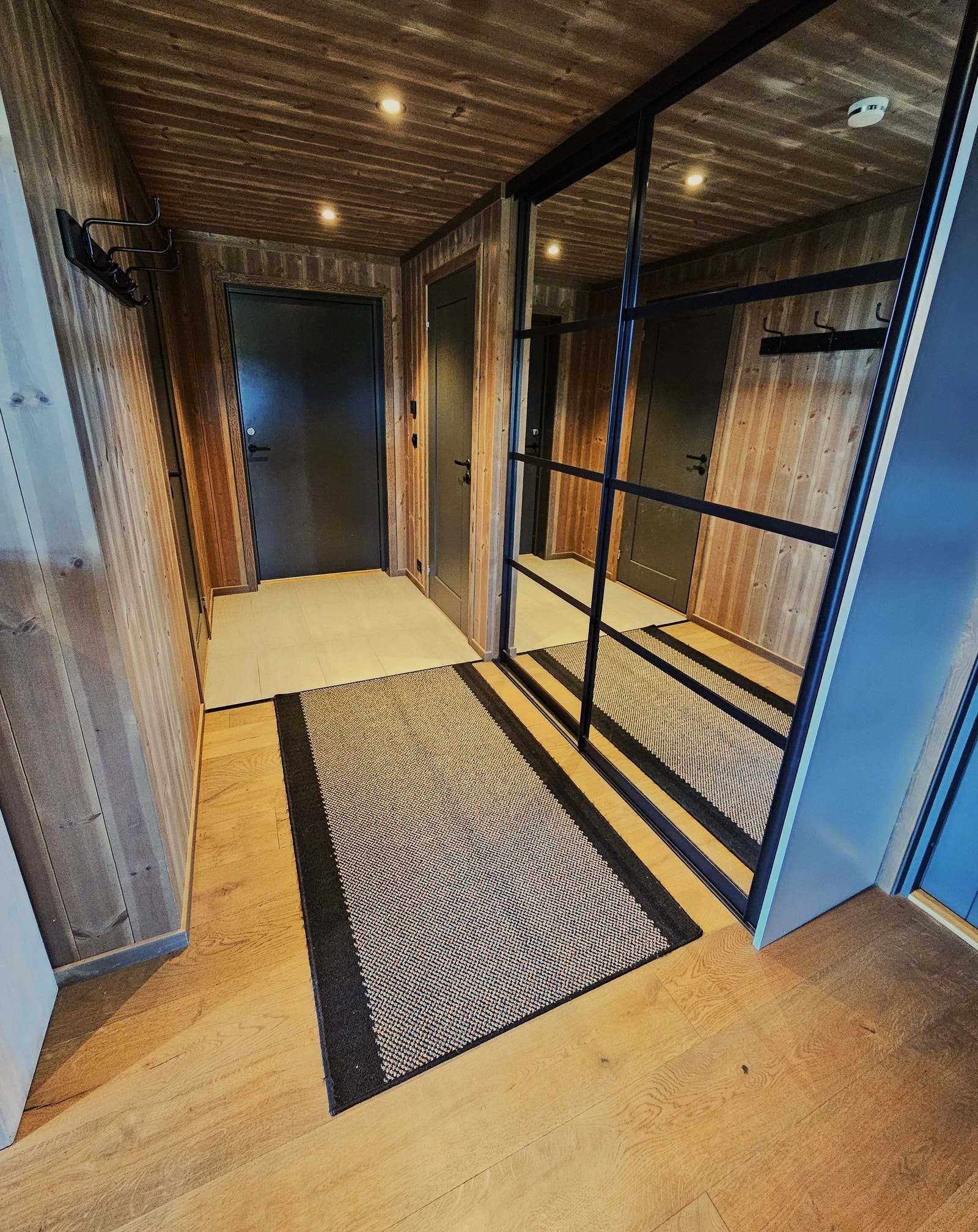 Romslig gang med flislagt entre og stor skyvedørsgarderobe. Varmekabler i gulv. Galleribilde