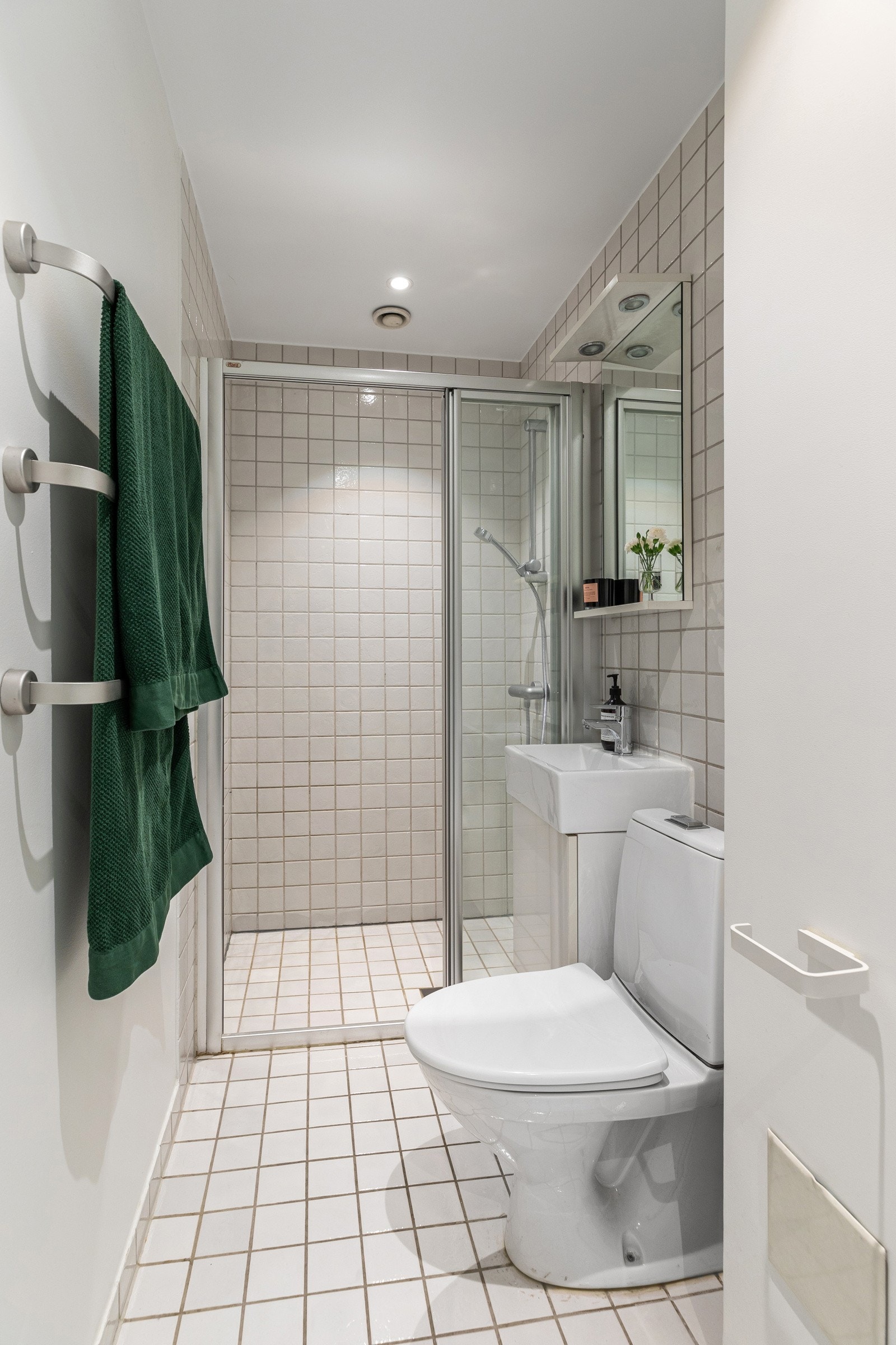 Flislagt baderom med varmekabler og romslig dusjnisje Galleribilde