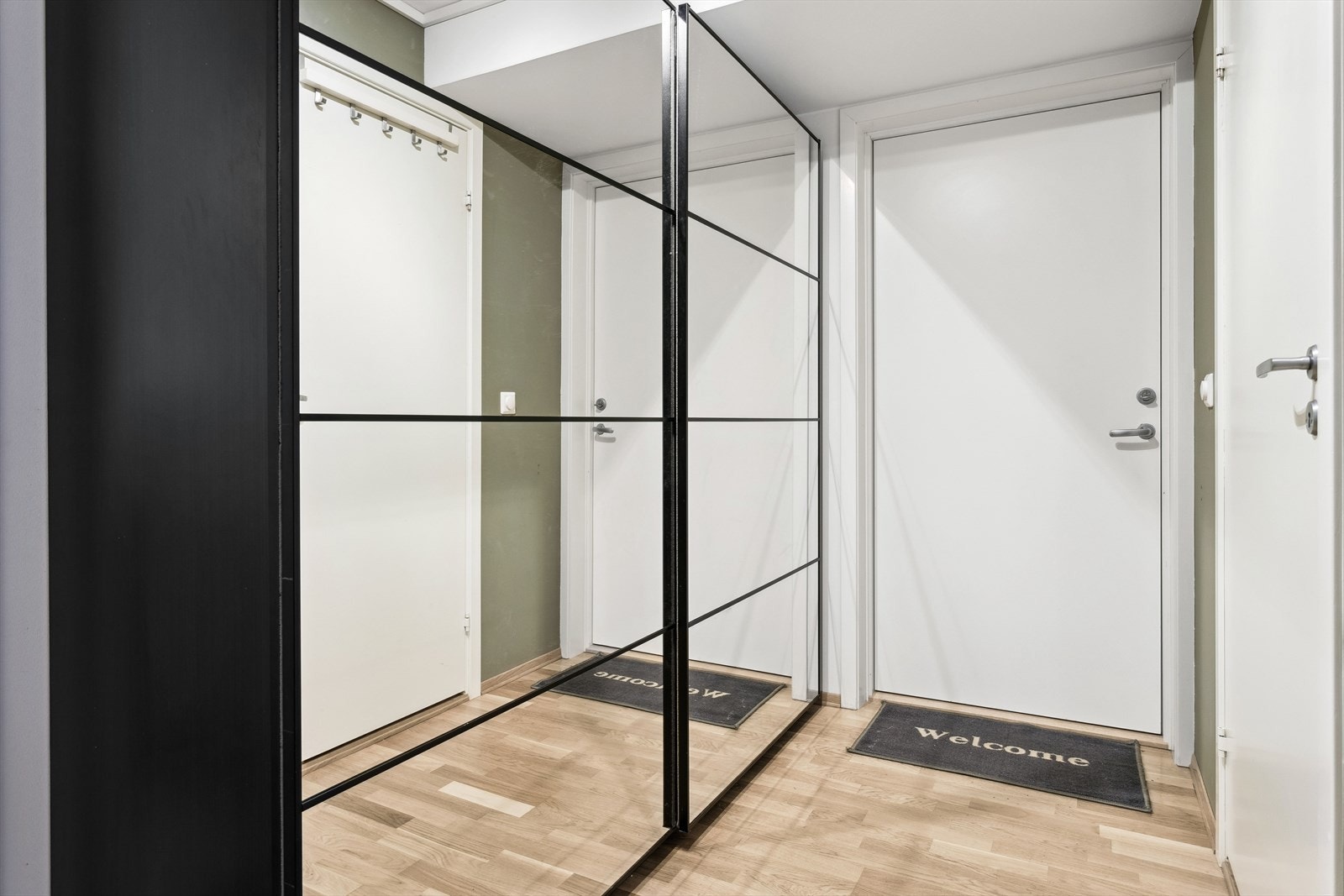 Entreen har parkettgulv og hvitmalte vegger, samt praktisk plass til oppbevaring. Galleribilde