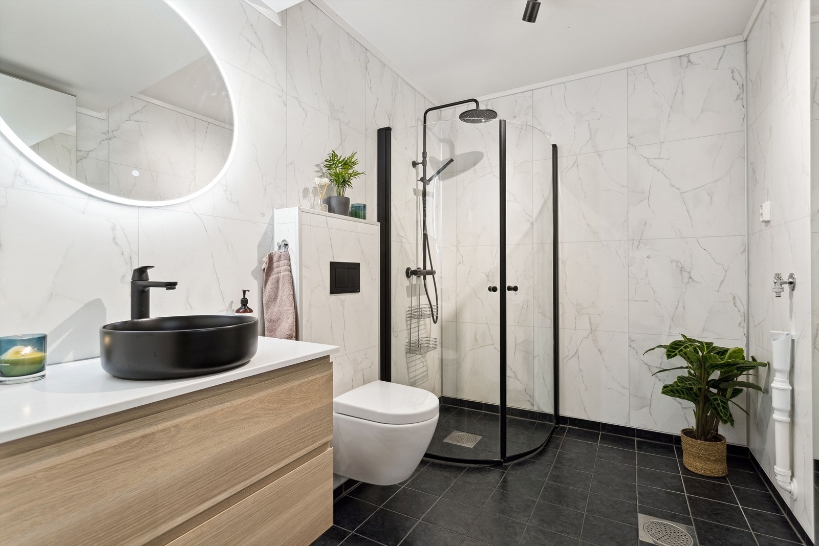 Leiligheten har et moderne bad som ble oppgradert i 2023, med nye baderomsplater og innredning. Galleribilde